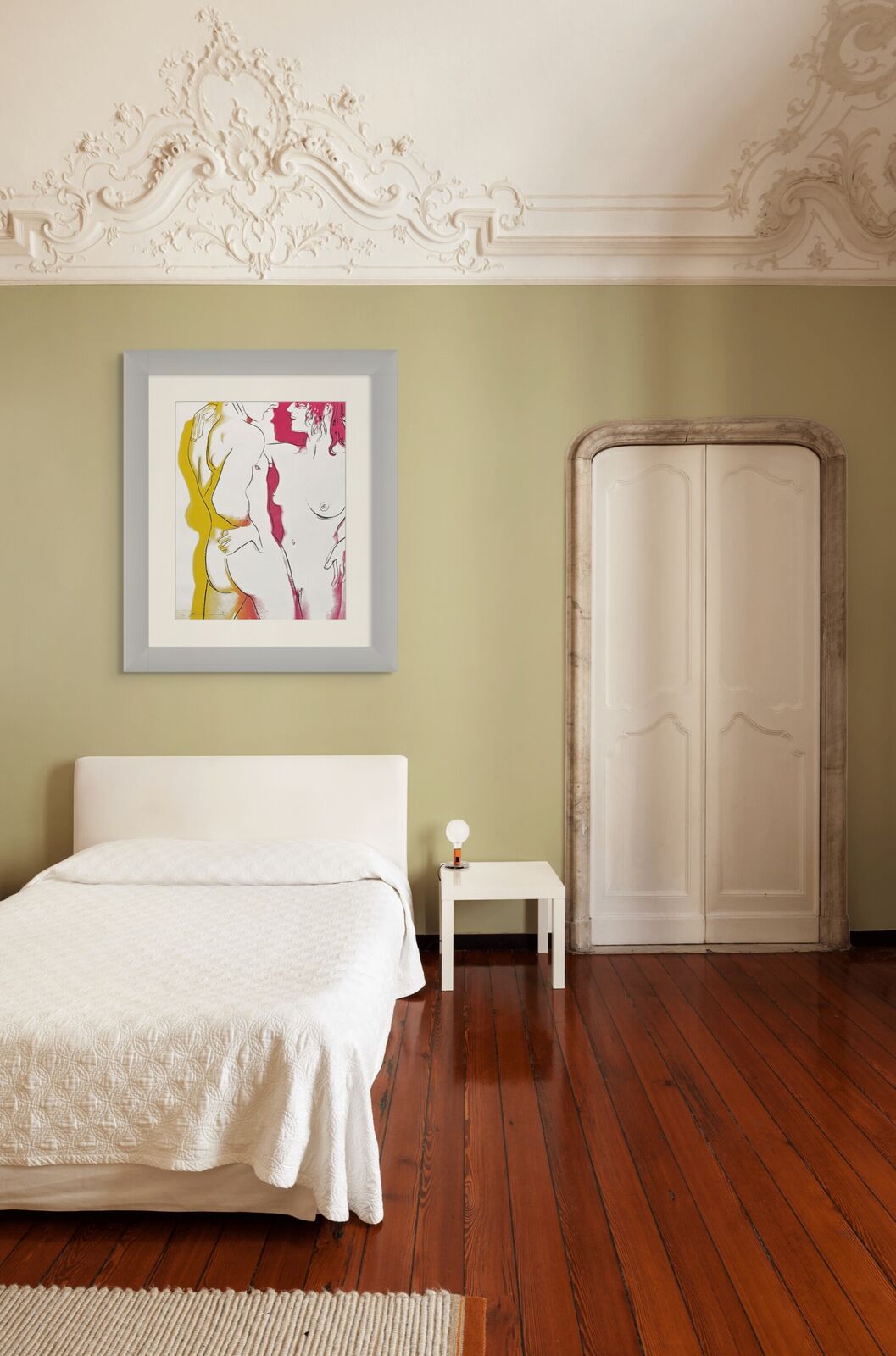 A bedroom with a bed and three framed pictures on the wall.