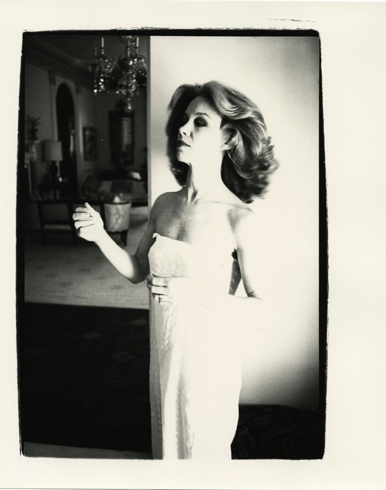 A black and white photo of a woman in a white dress.