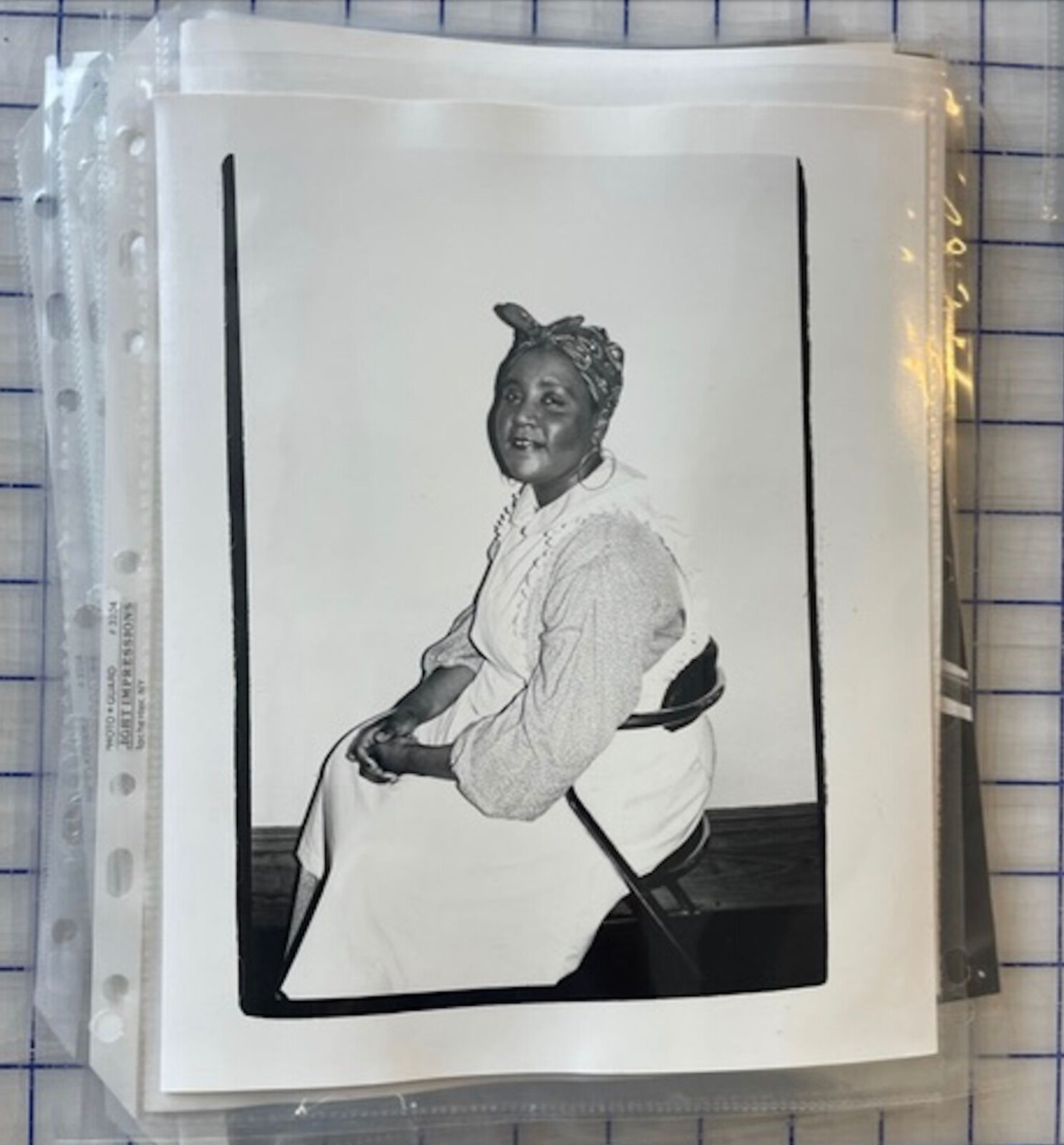 A black and white photo of a woman sitting on a chair.