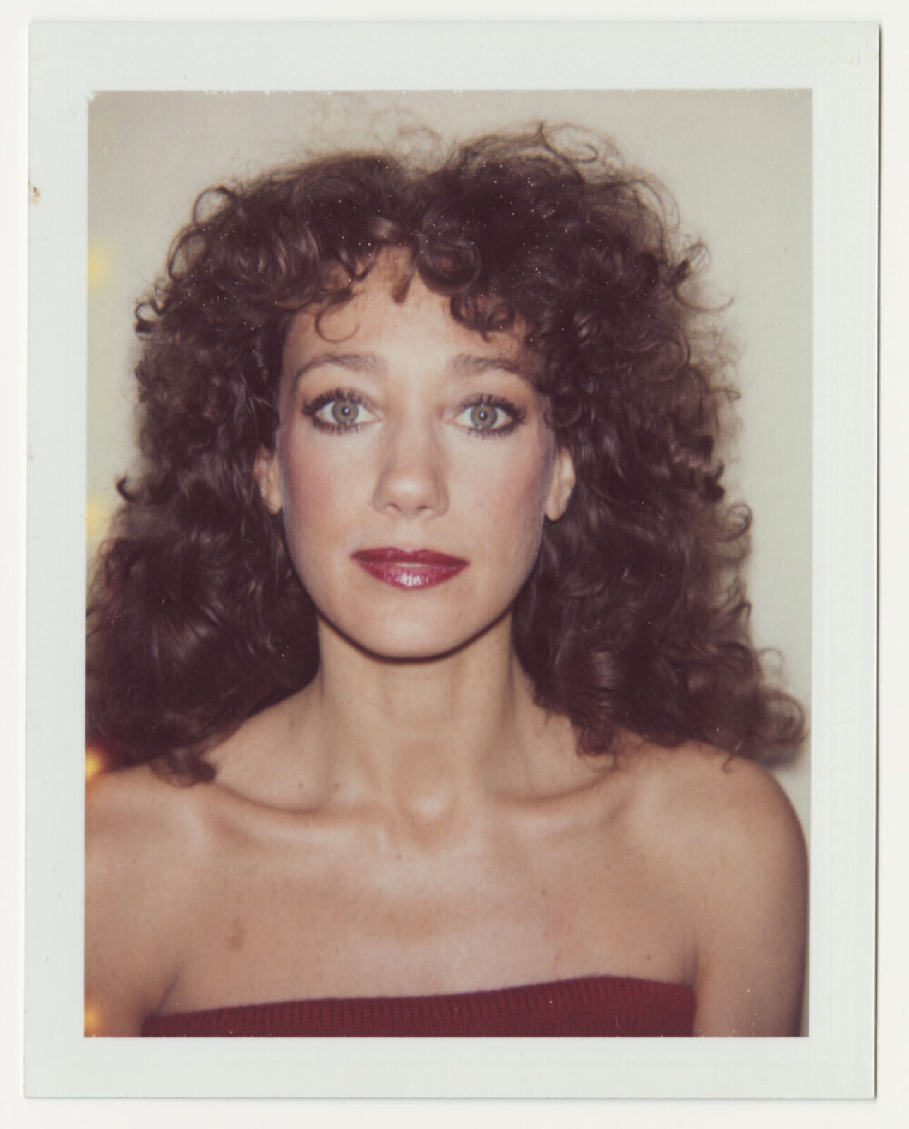 A woman with curly hair wearing a red dress.
