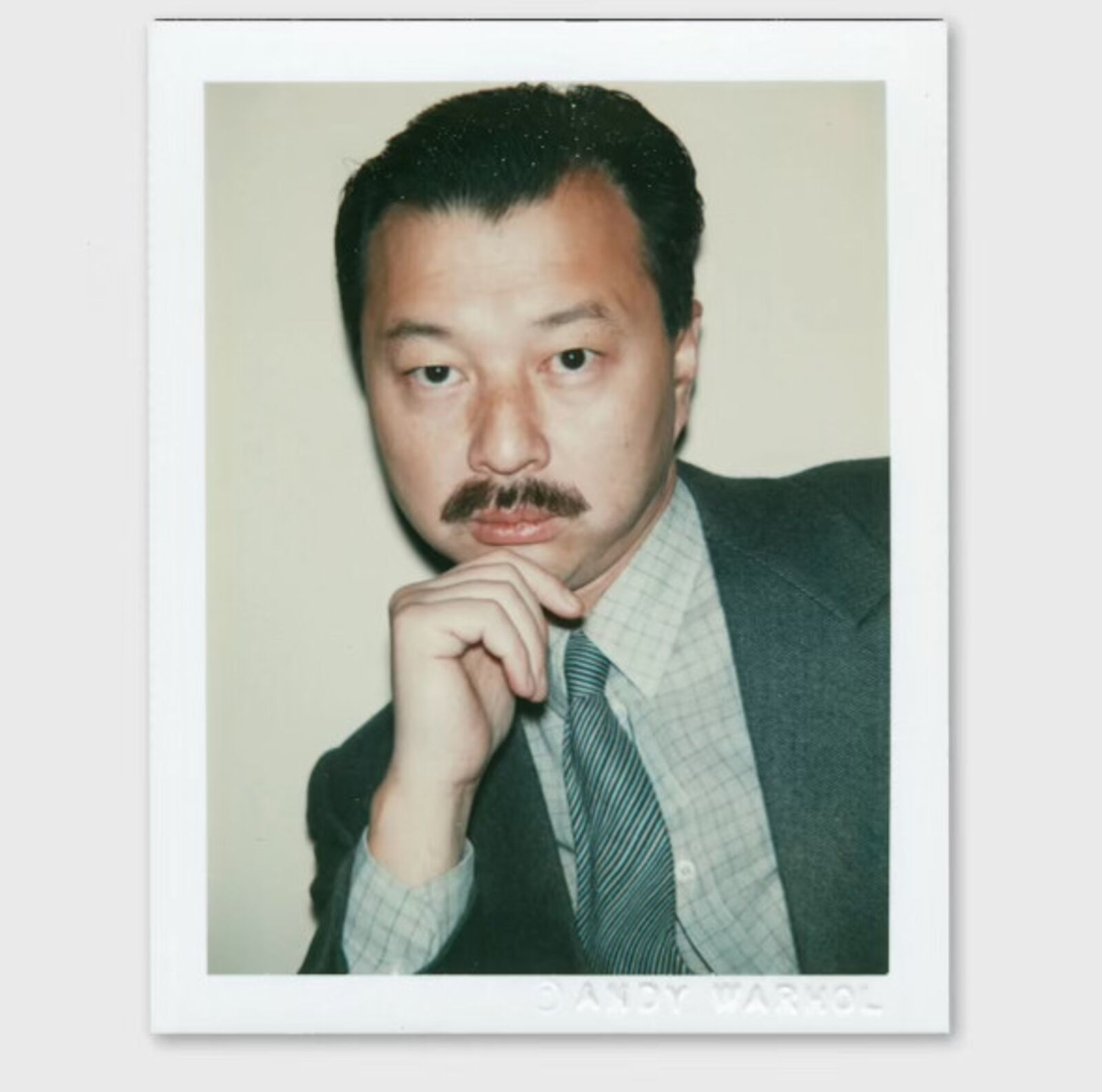 A man with a moustache and a tie is posing for a picture.