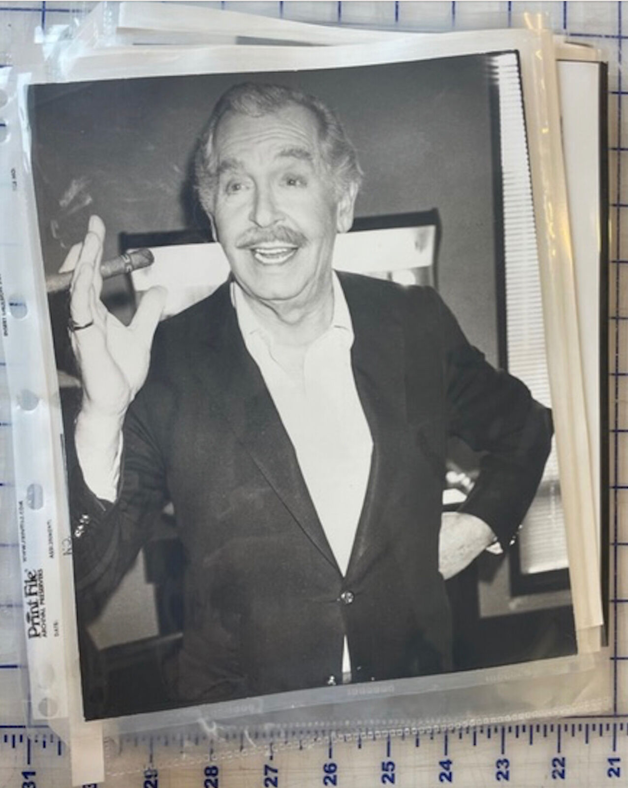 A black and white photo of a man in a suit smoking a cigar.