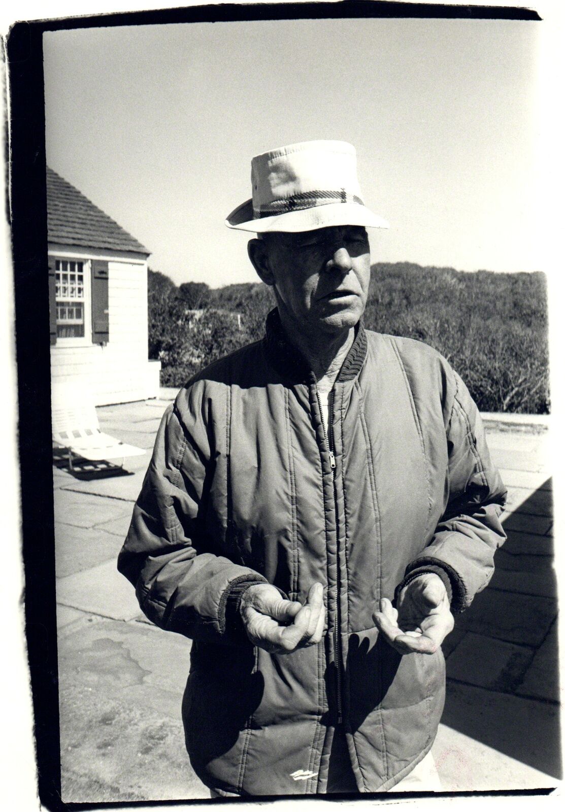 A black and white photo of a man wearing a hat.