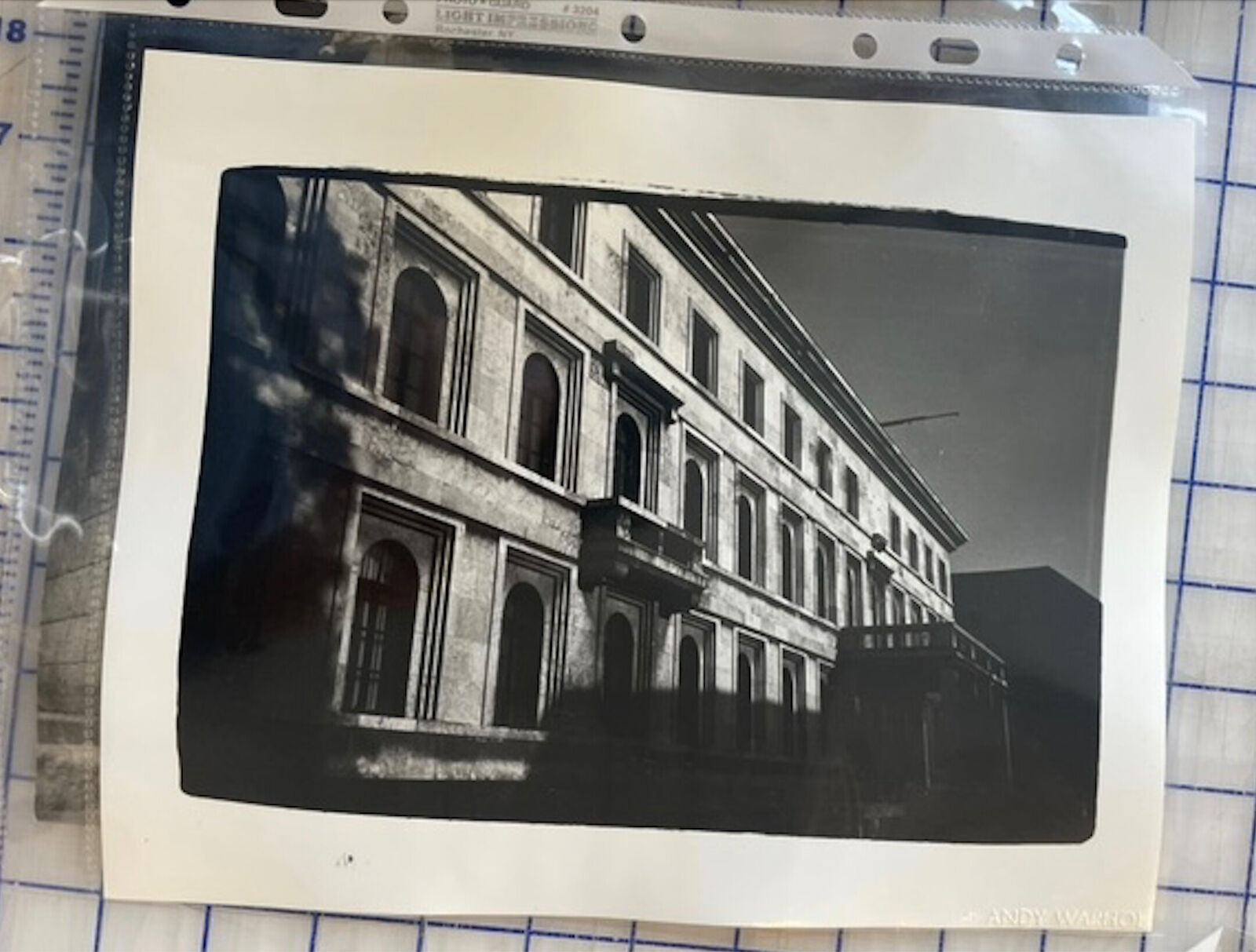 A black and white photo of a building with many windows.