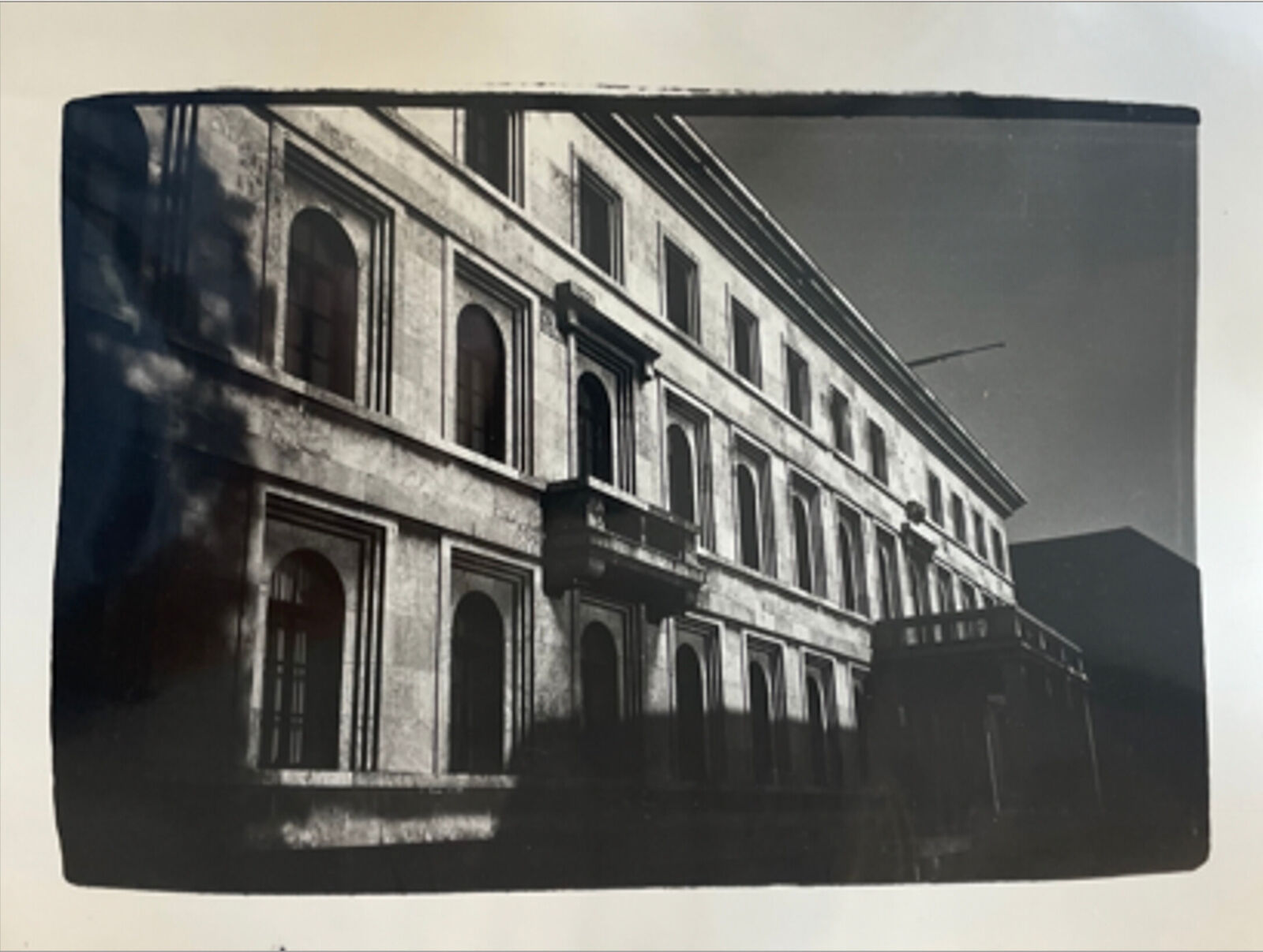 A black and white photo of a building with many windows.