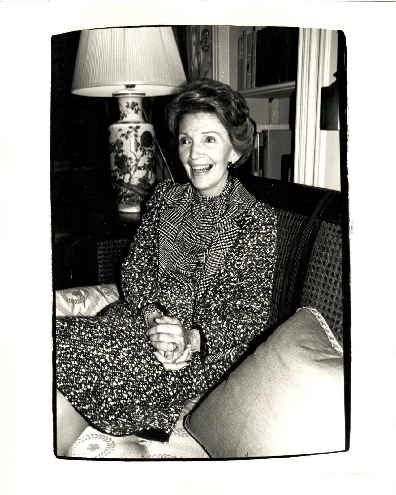 A black and white photo of a woman sitting on a couch.