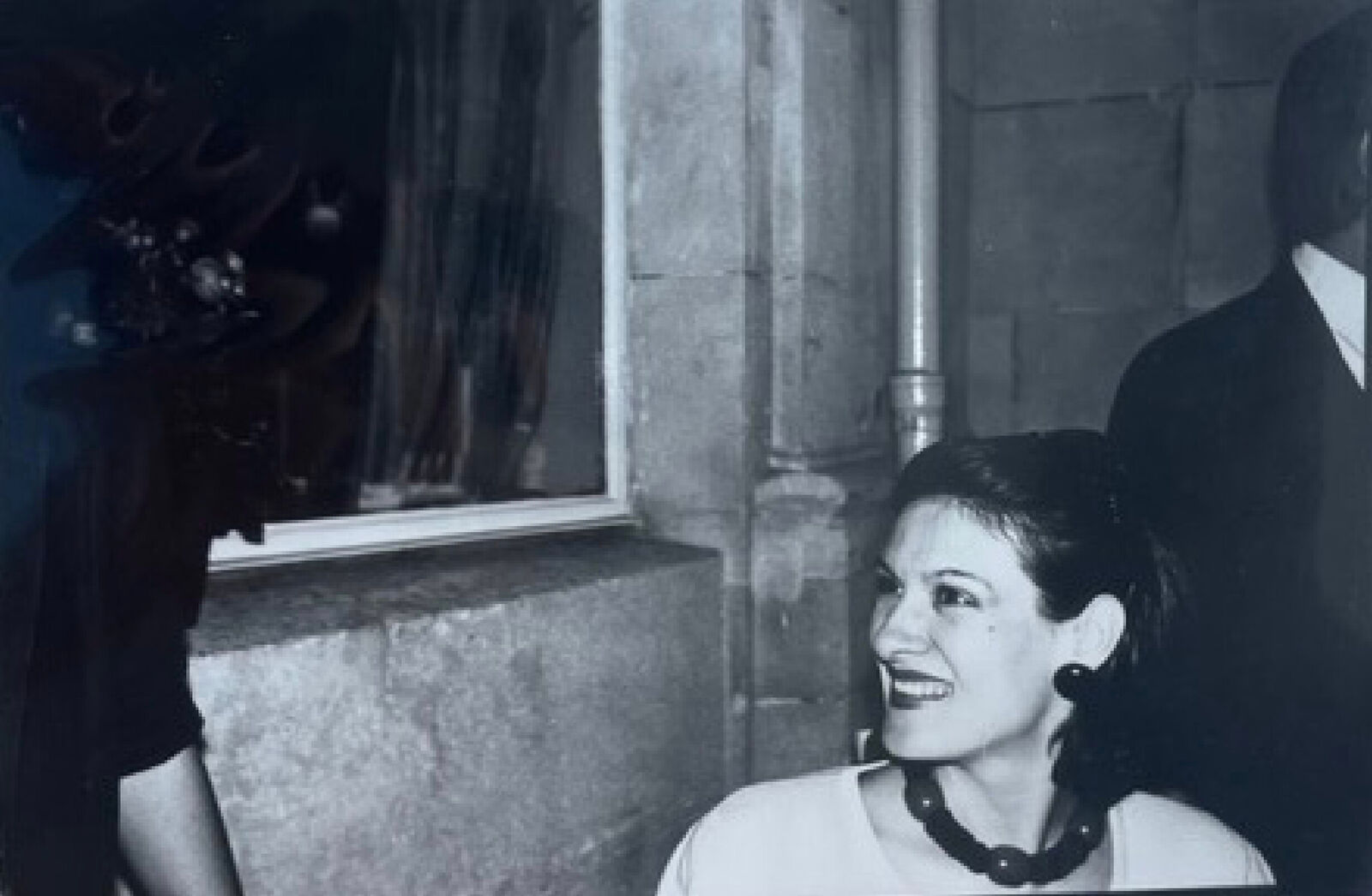 A black and white photo of a woman smiling at a man.