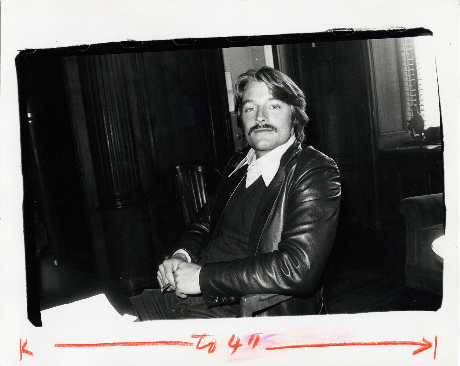 A black and white photo of a man with a mustache.