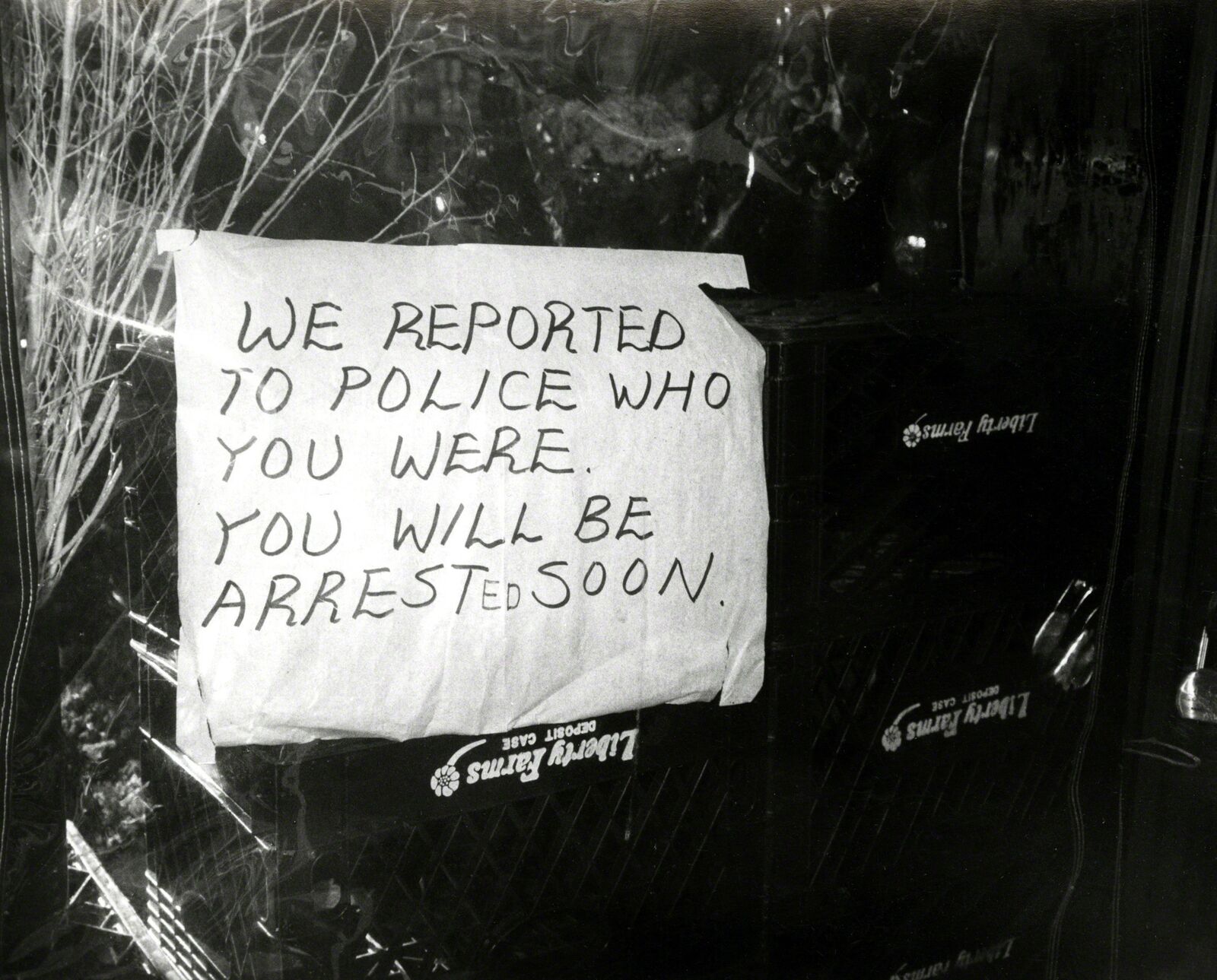 A sign posted on the door of a police station that says we reported to police who you were.