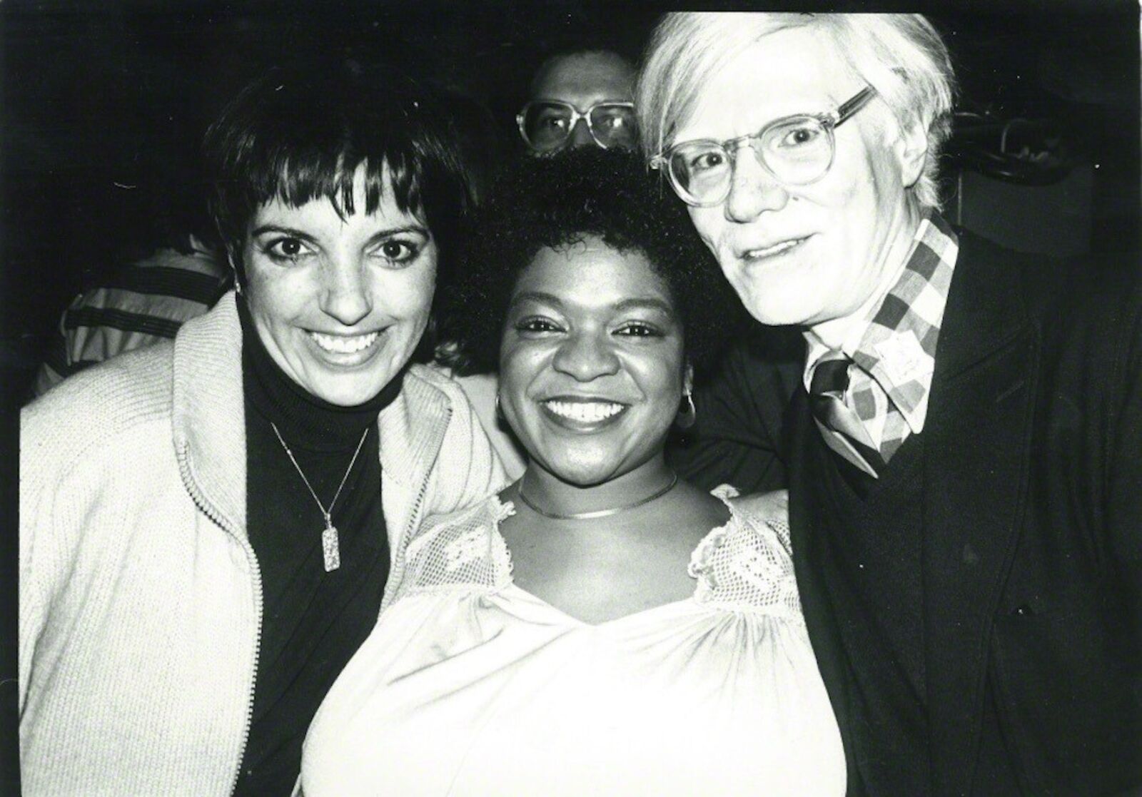 A black and white photo of two women and a man.