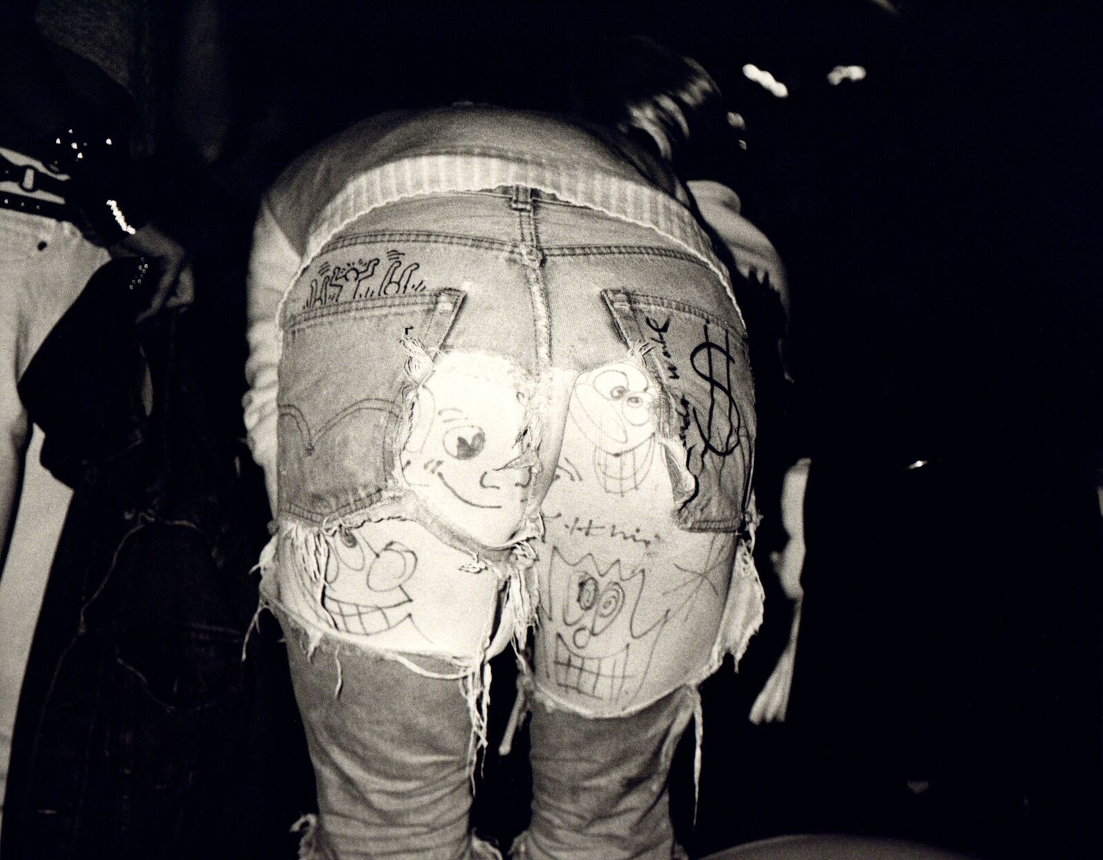 A pair of jeans with drawings on the back of them.