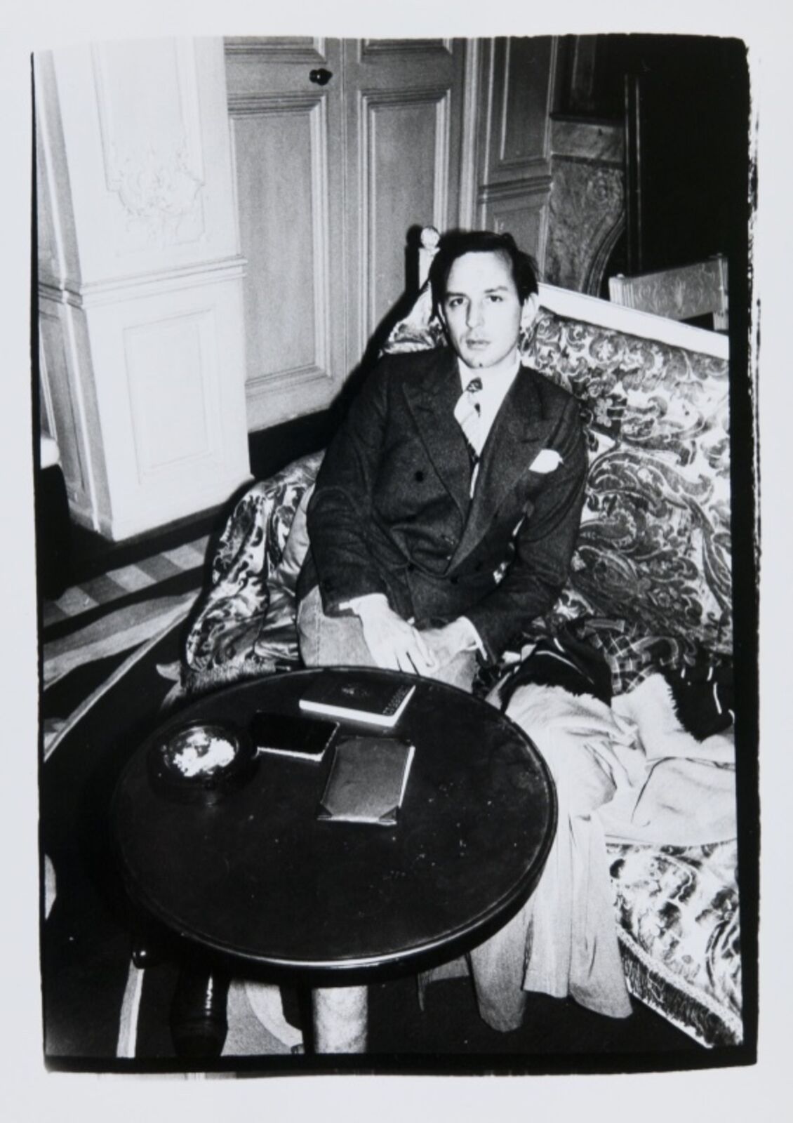 A man sitting on a couch next to a table.