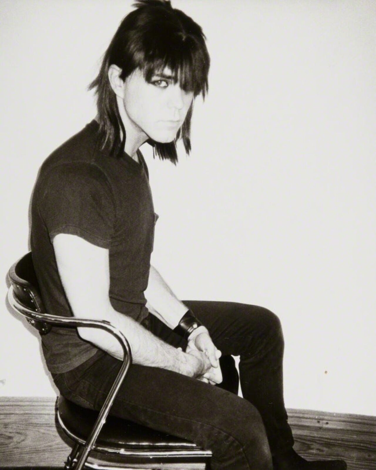 A man sitting on a chair with his legs crossed.