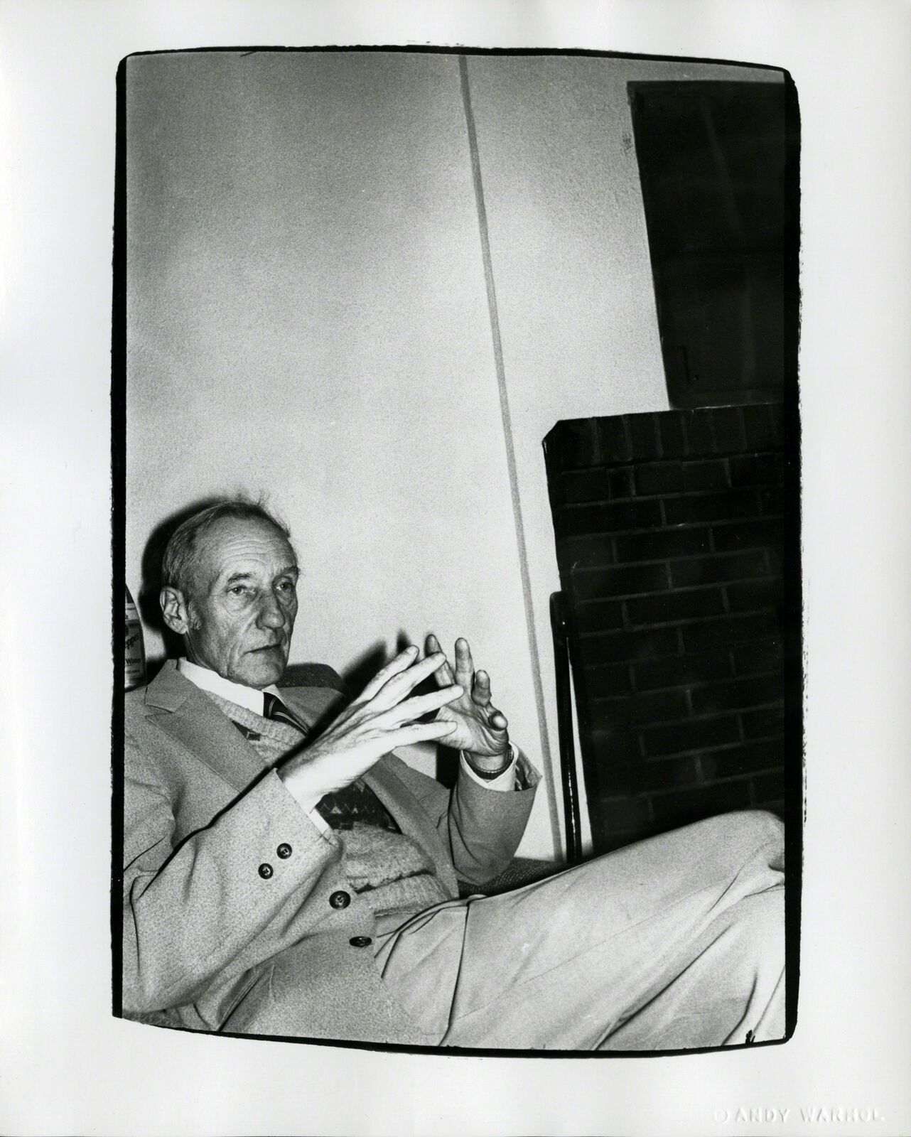 A black and white photo of a man sitting in a chair.