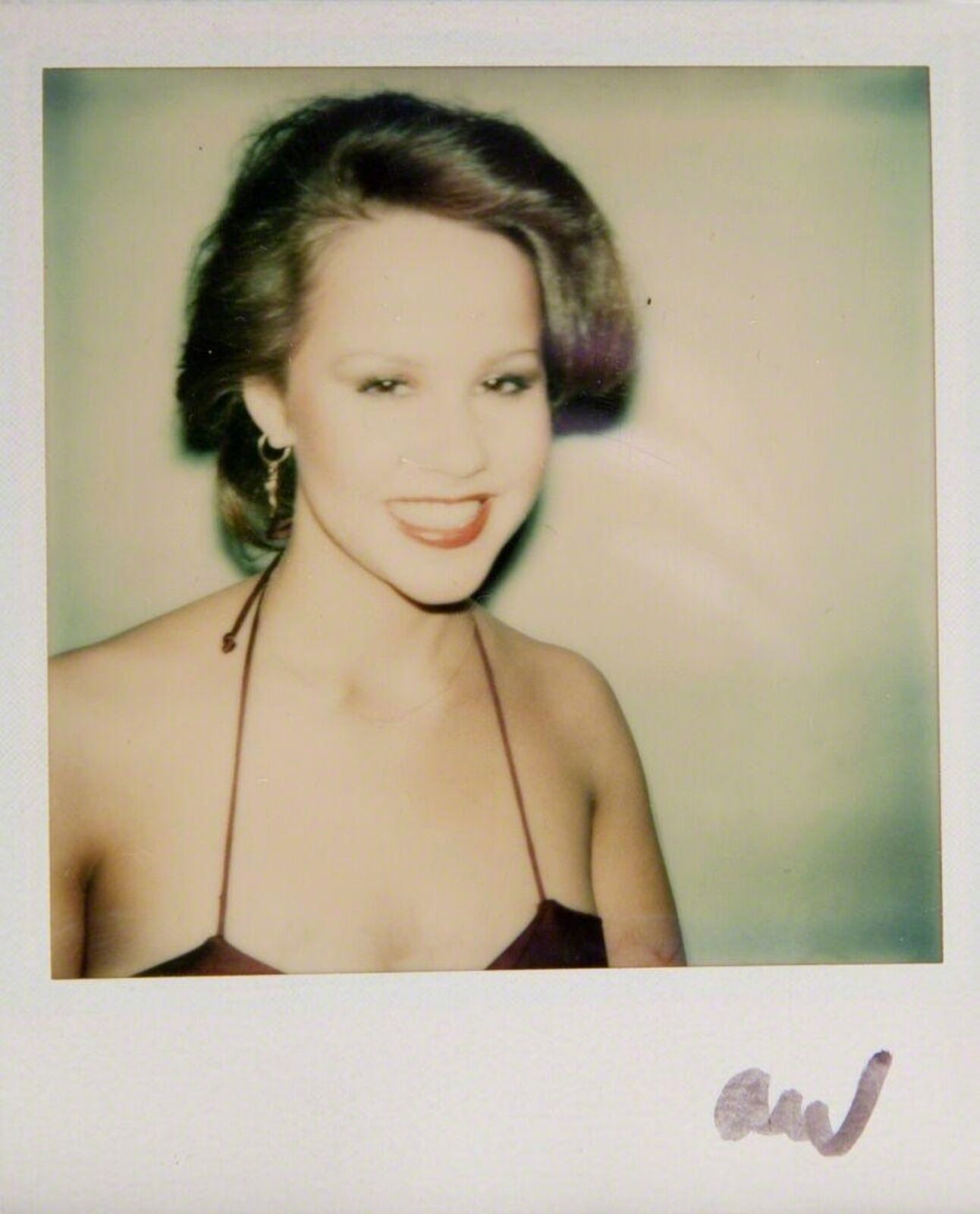 A polaroid photo of a woman in a brown dress.