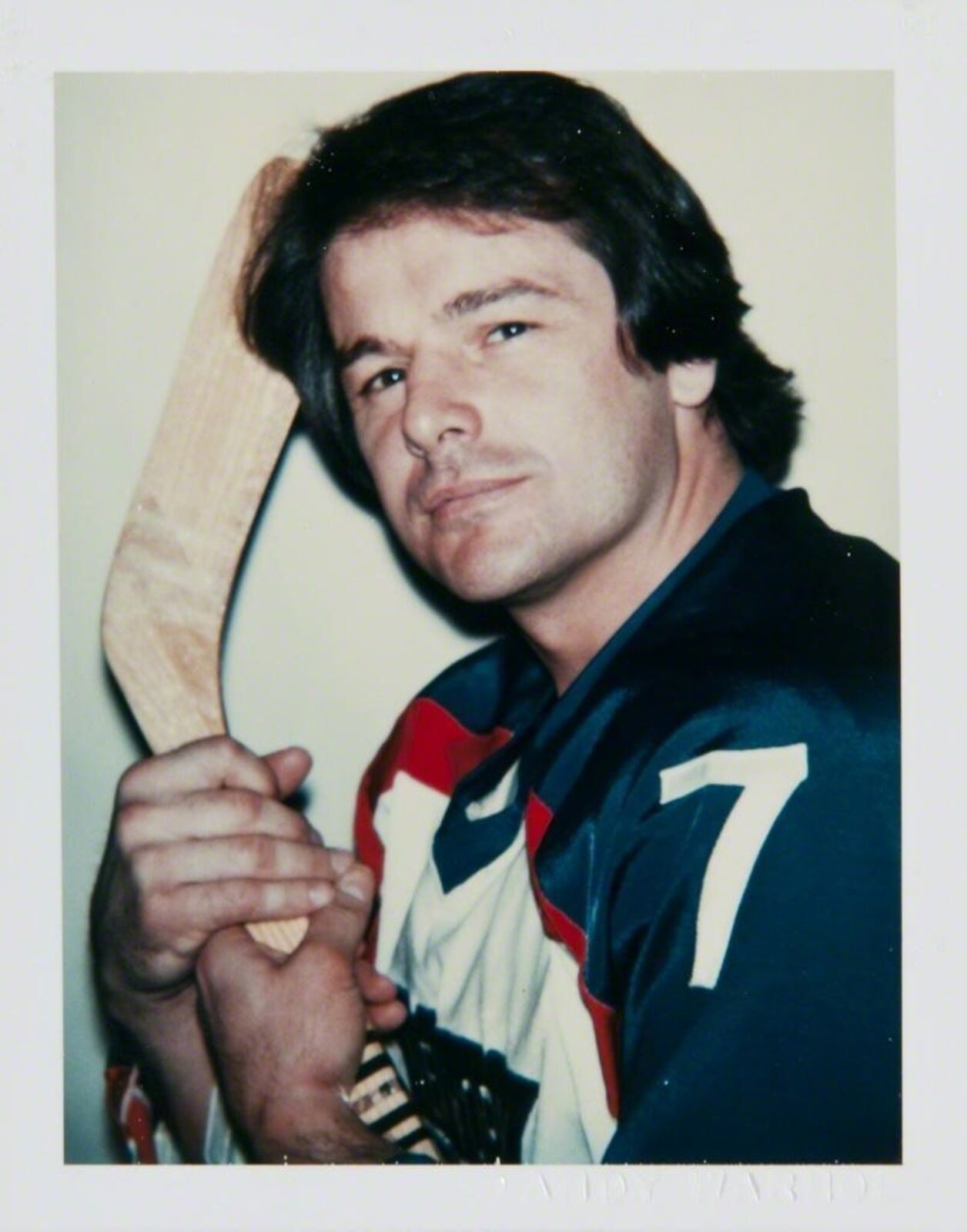 A man holding a hockey stick in his hand.