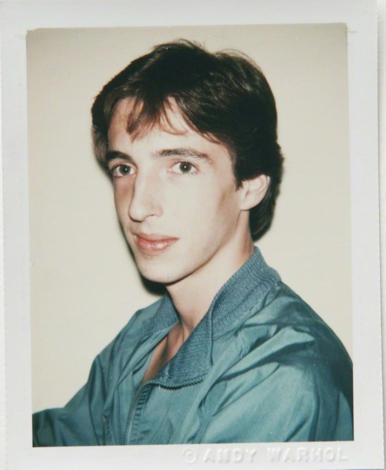 A young man in a blue shirt is posing for a picture.