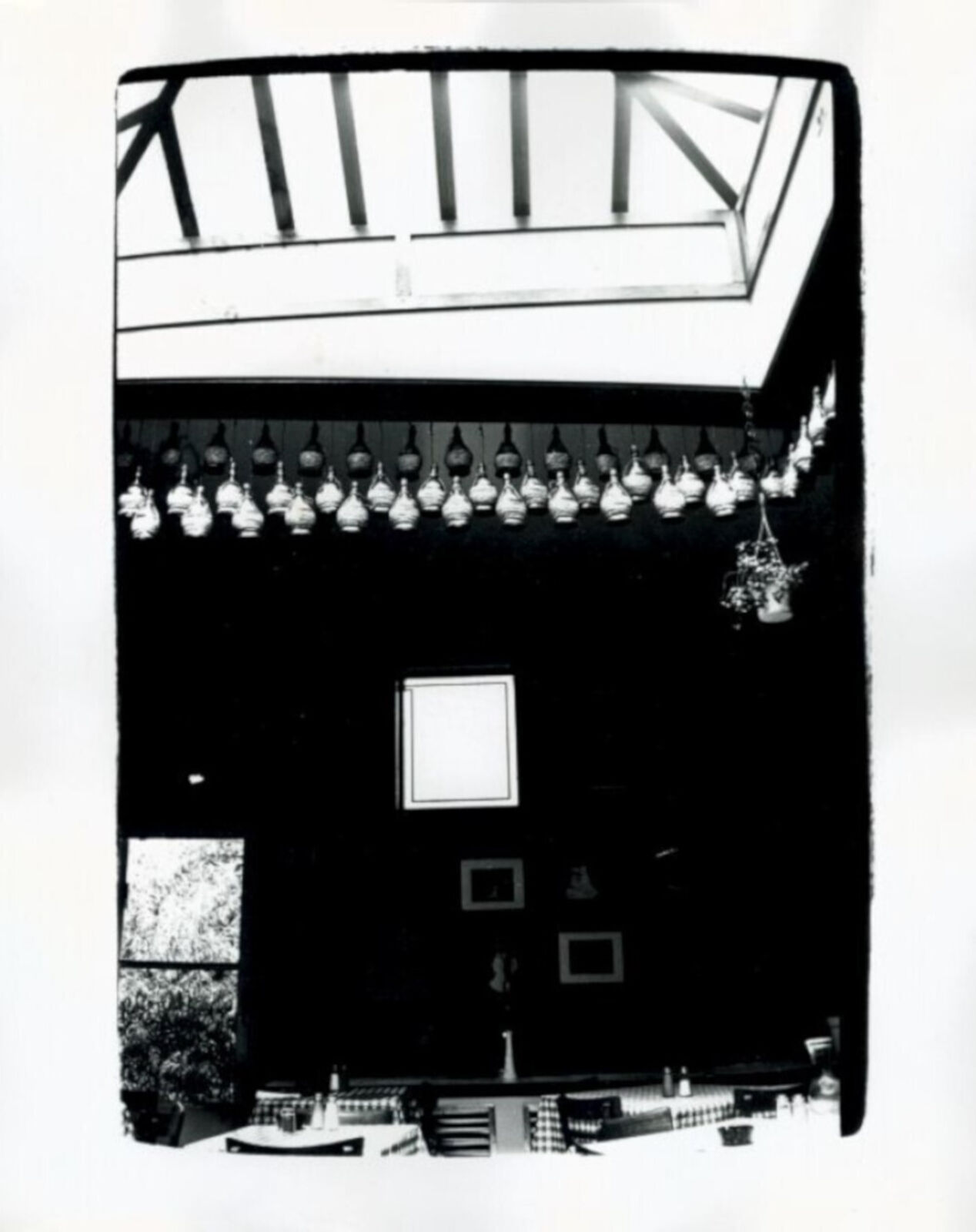 A black and white photo of a room with a skylight.