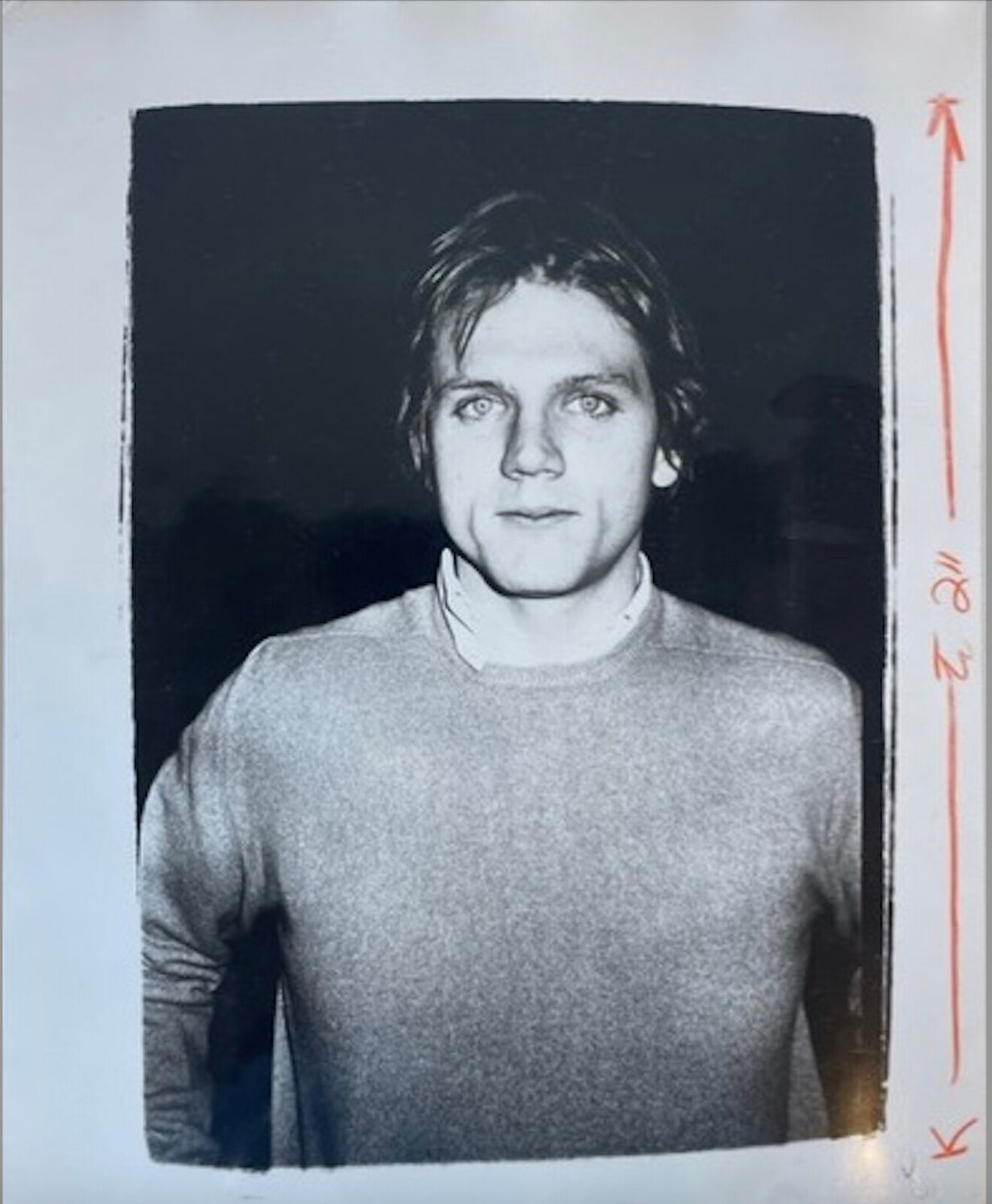 A black and white photo of a man in a sweater.