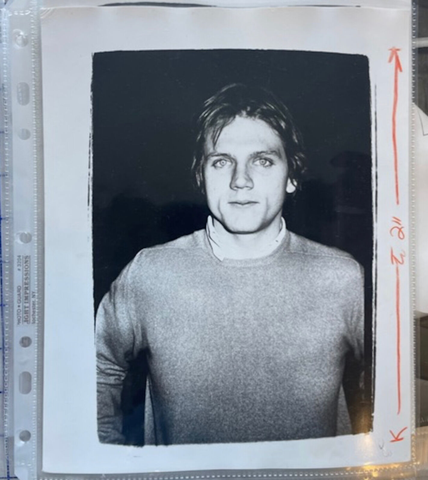 A black and white photo of a man in a sweater.