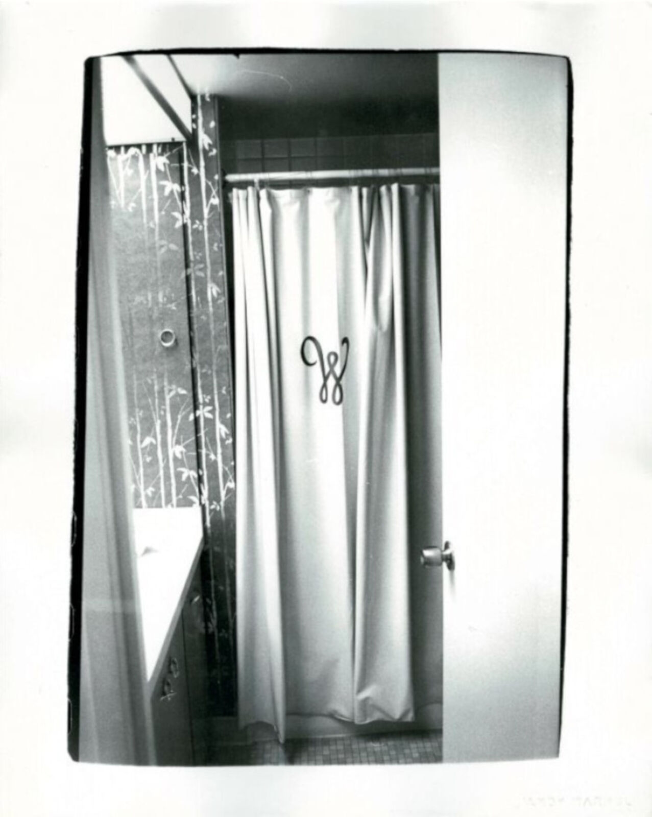 A black and white photo of a bathroom with a shower curtain.