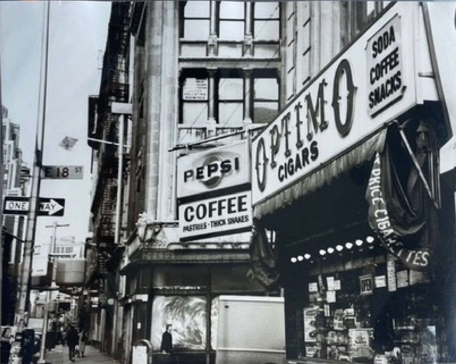A black and white photo of a coffee shop on a city street.