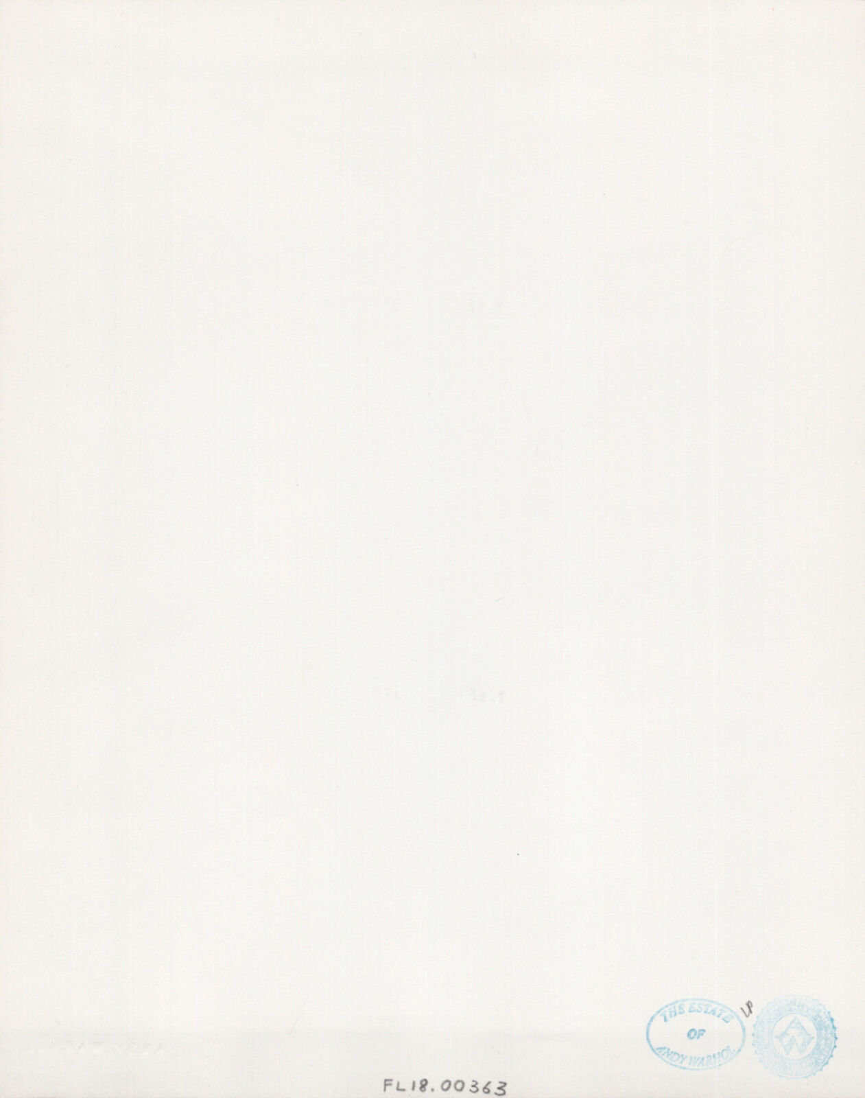 A black and white photo of a table with a lamp and a vase of flowers.