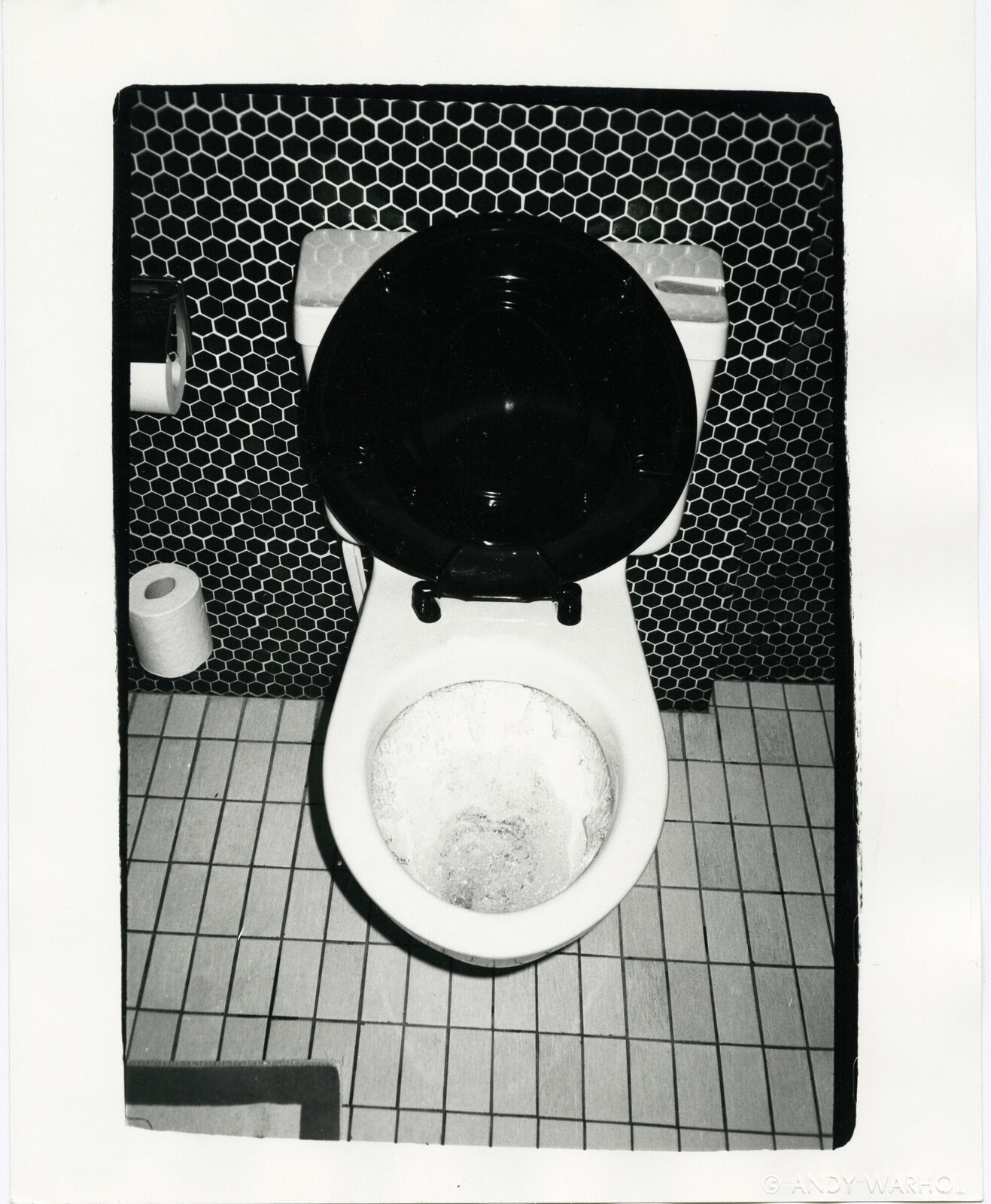 A black and white photo of a toilet in a bathroom.