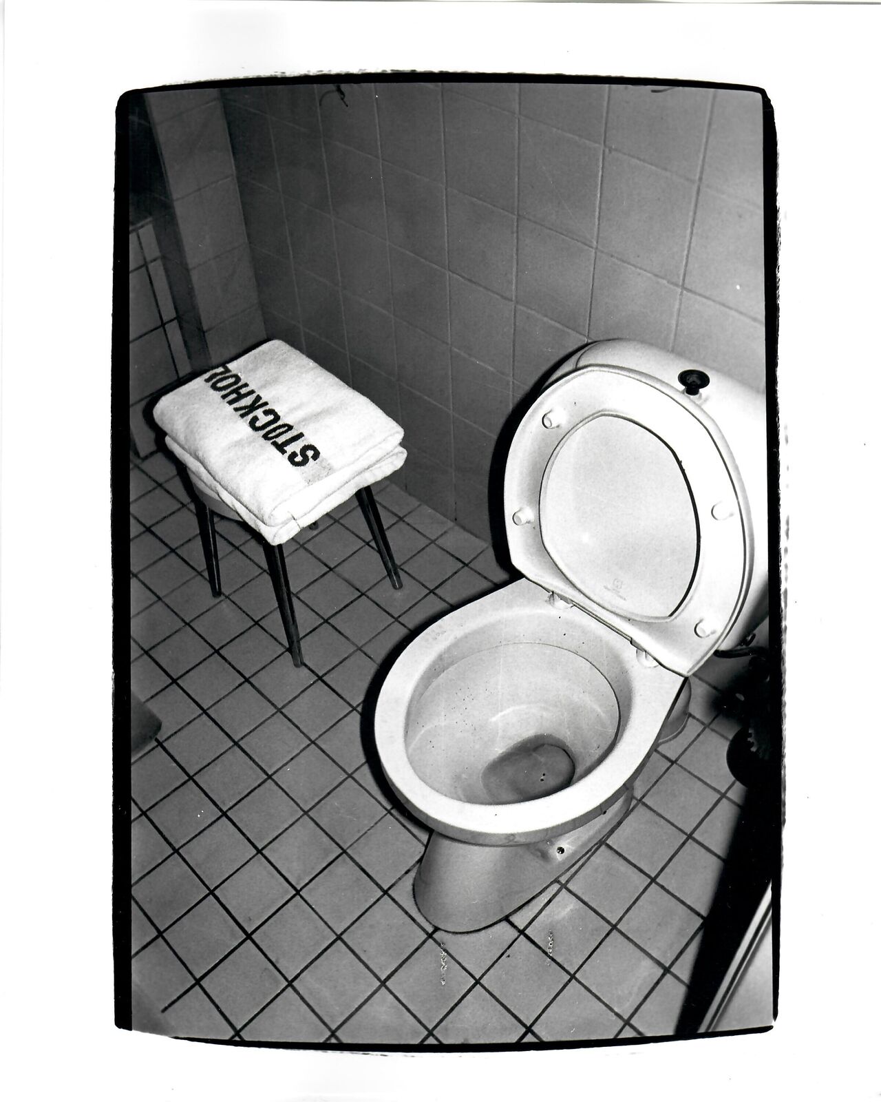A black and white photo of a toilet in a bathroom.