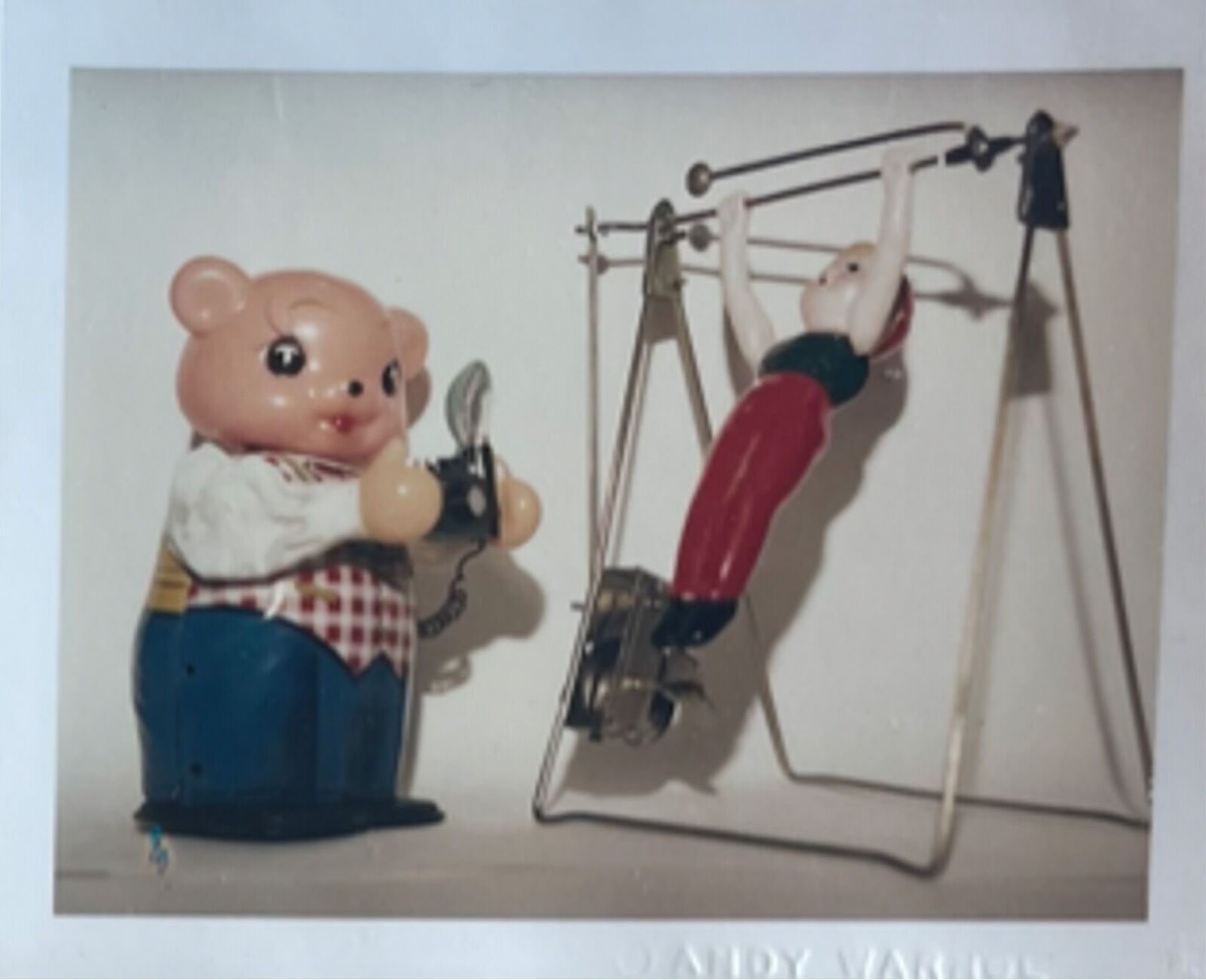 A picture of a piggy bank with a man on a swing set.
