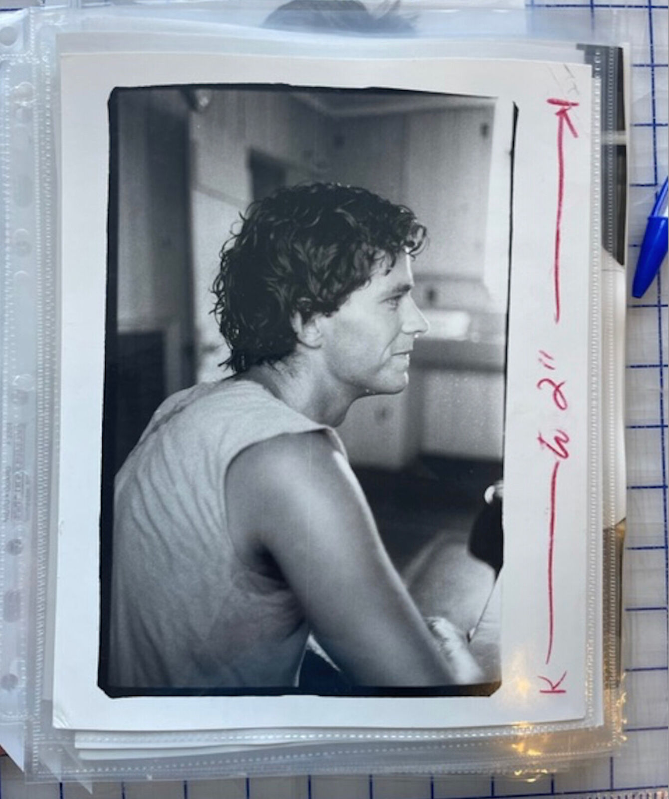 A black and white photo of a man with curly hair.
