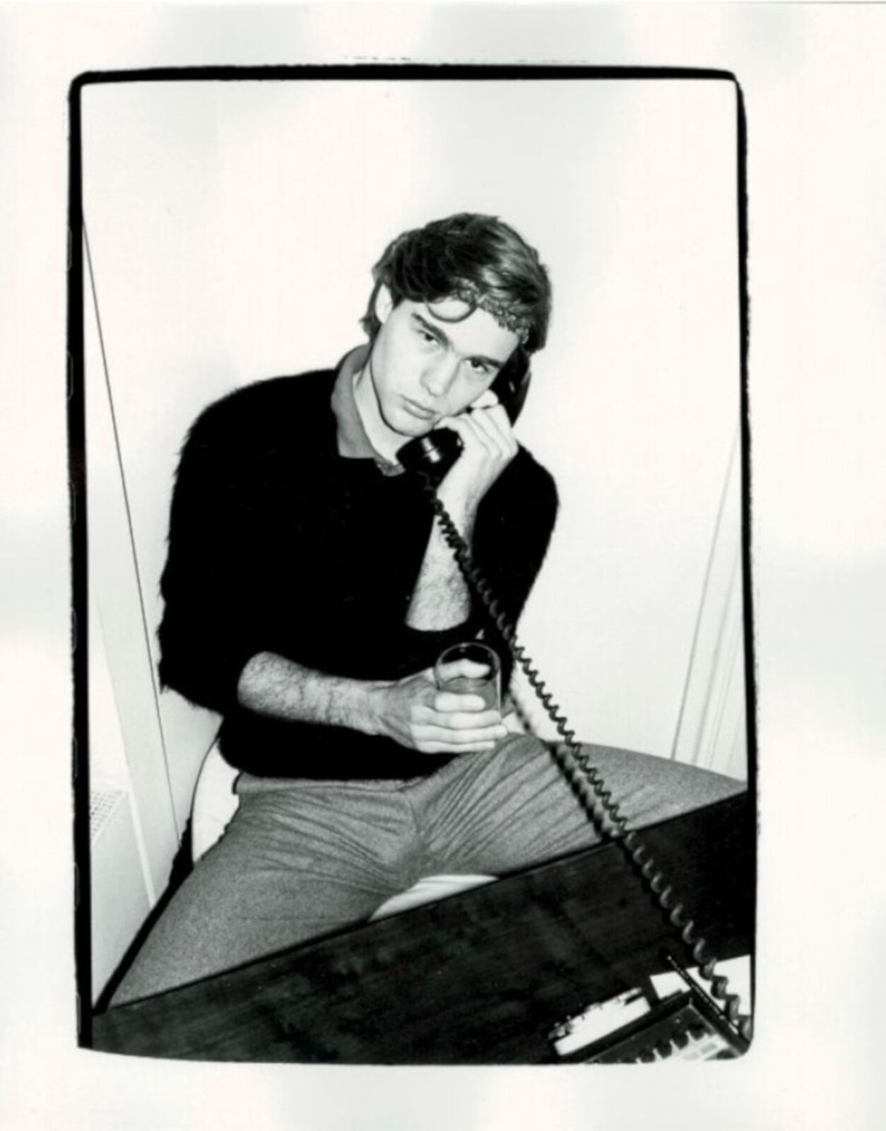A man sitting at a piano talking on a phone.