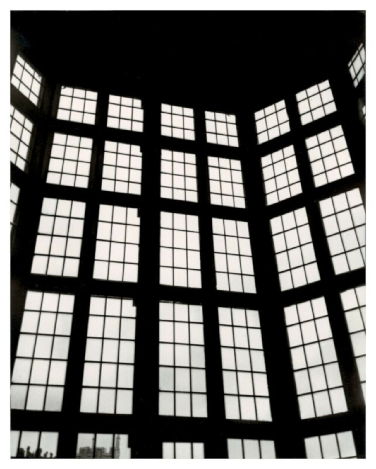 A black and white photo of a large window in a building.