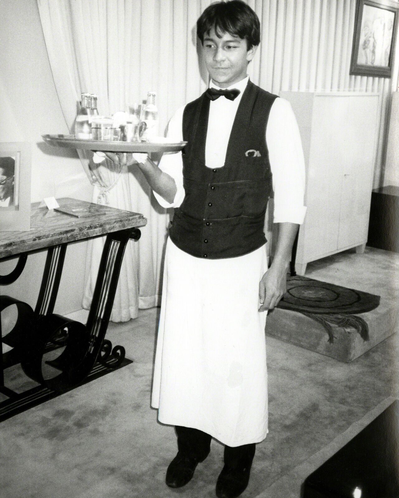 A man in a tuxedo holding a tray of food.