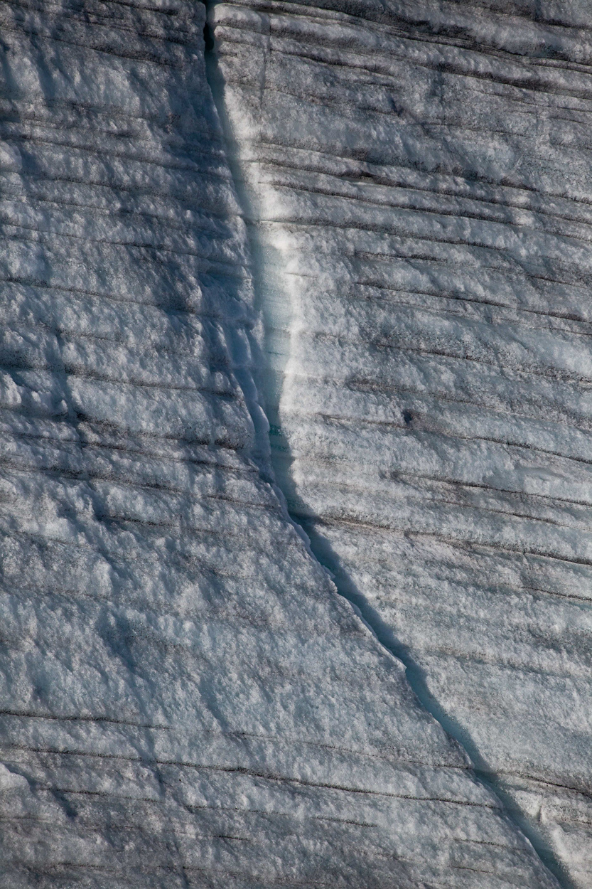 A close up of a crack in the ice on a mountain.