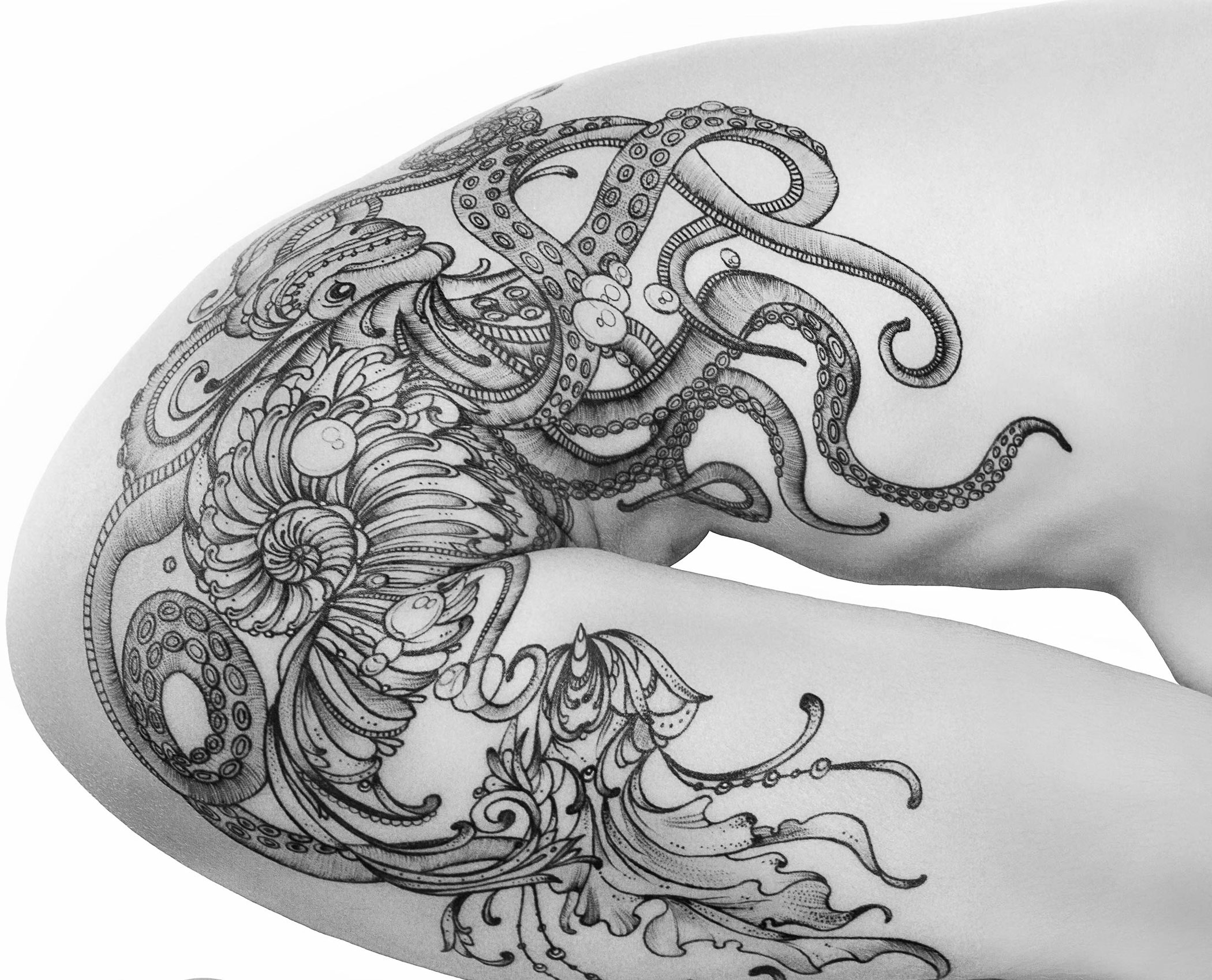 A black and white drawing of an octopus on a woman's thigh.
