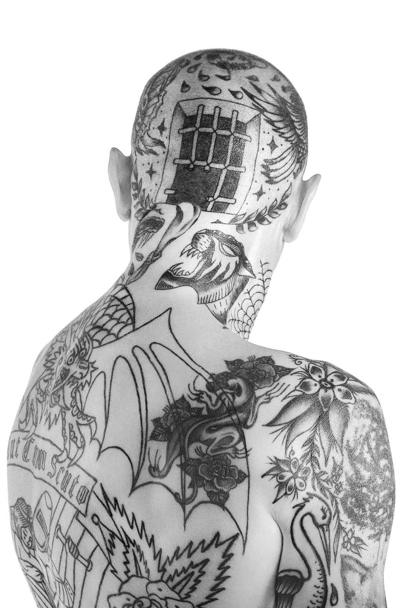 A man with a tattoo on his back with a window on his head.