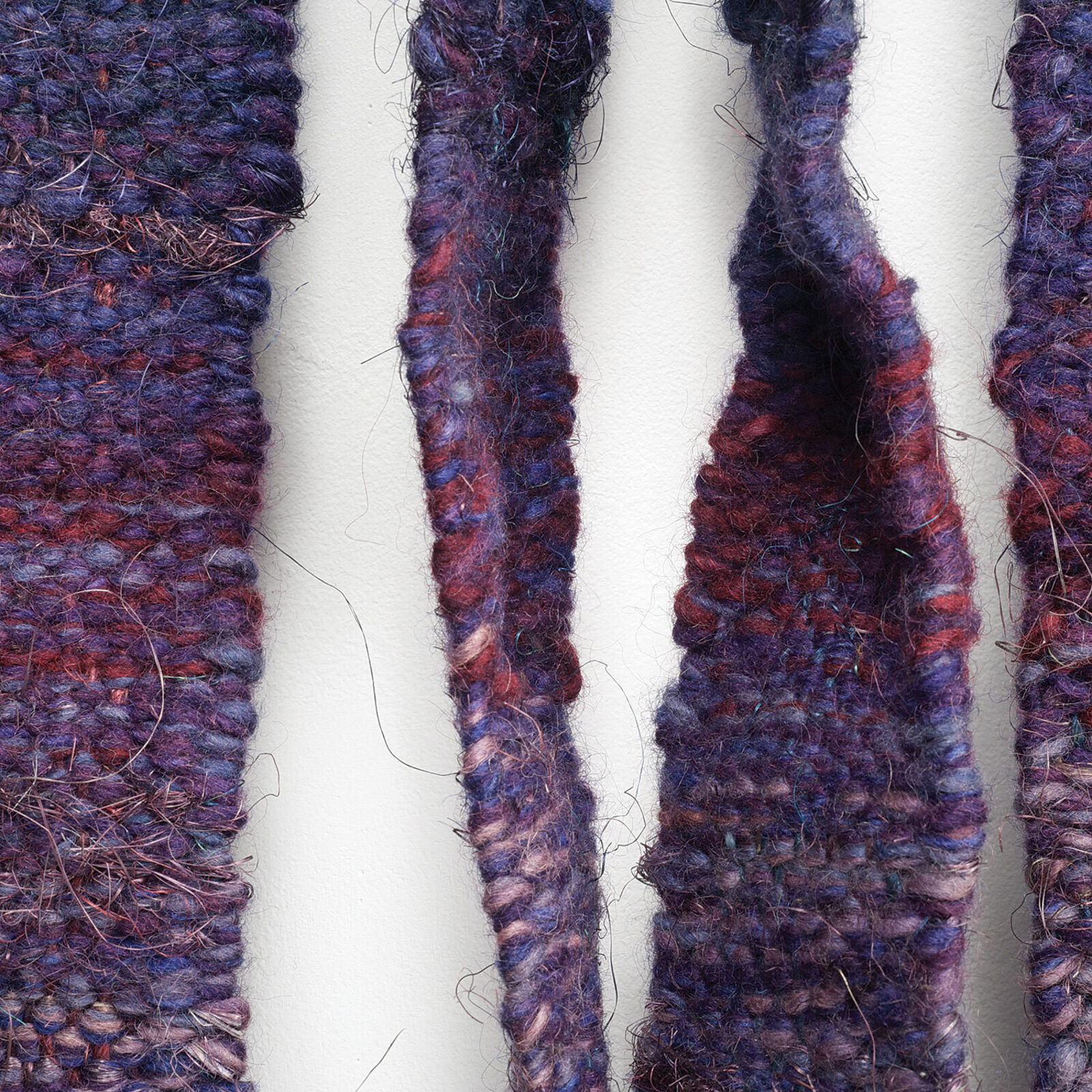 A blue and purple wall hanging on a white wall.