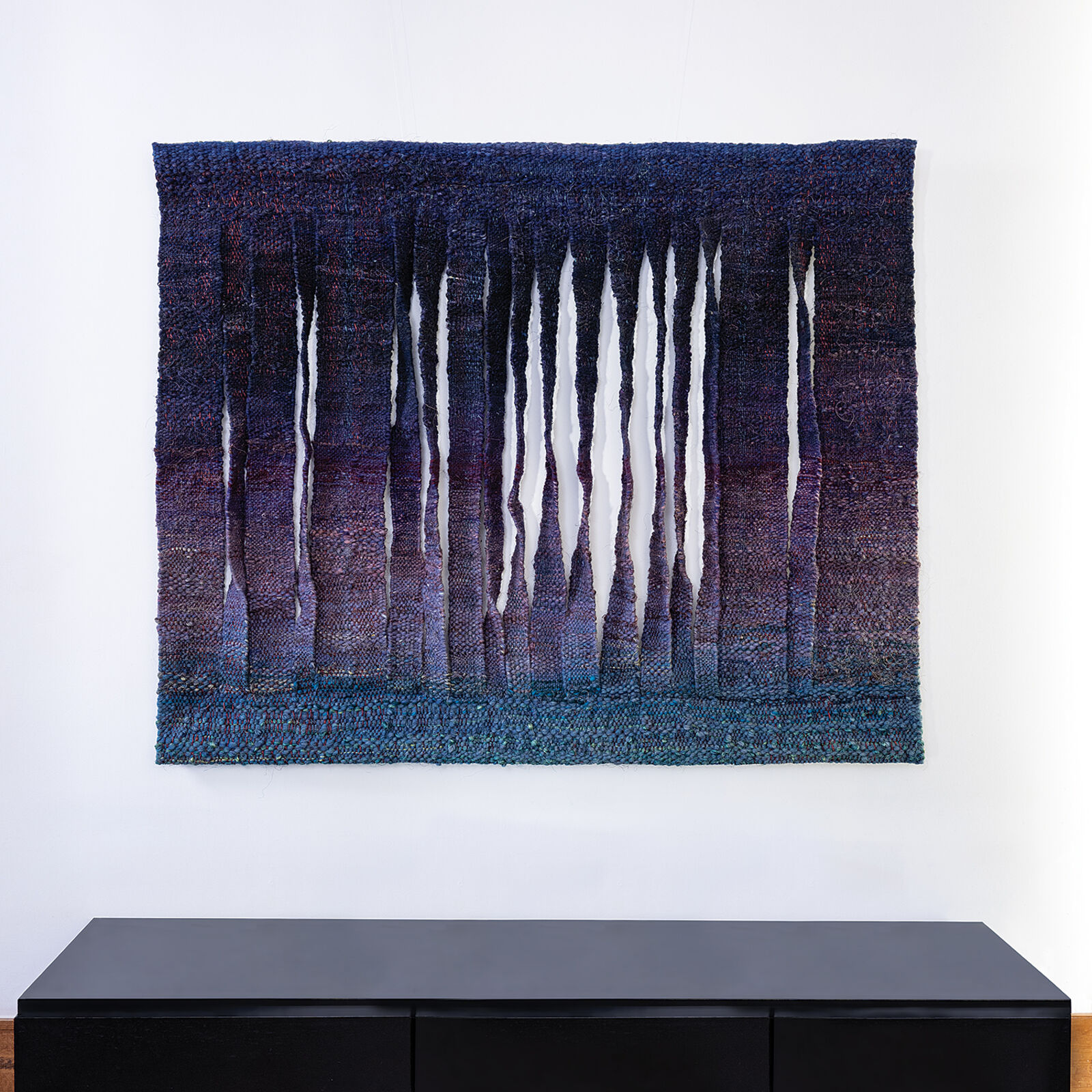 A blue and purple wall hanging on a white wall.