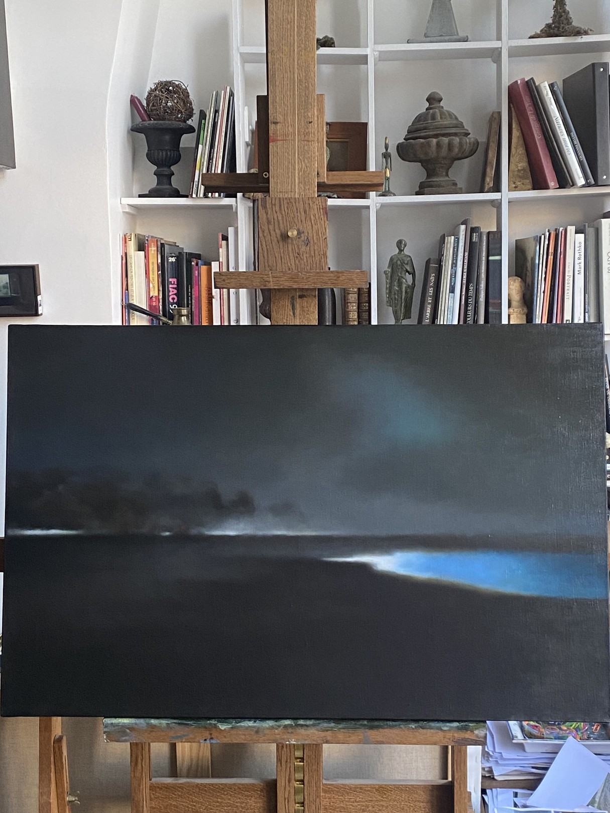 A painting of a dark sky over a body of water.