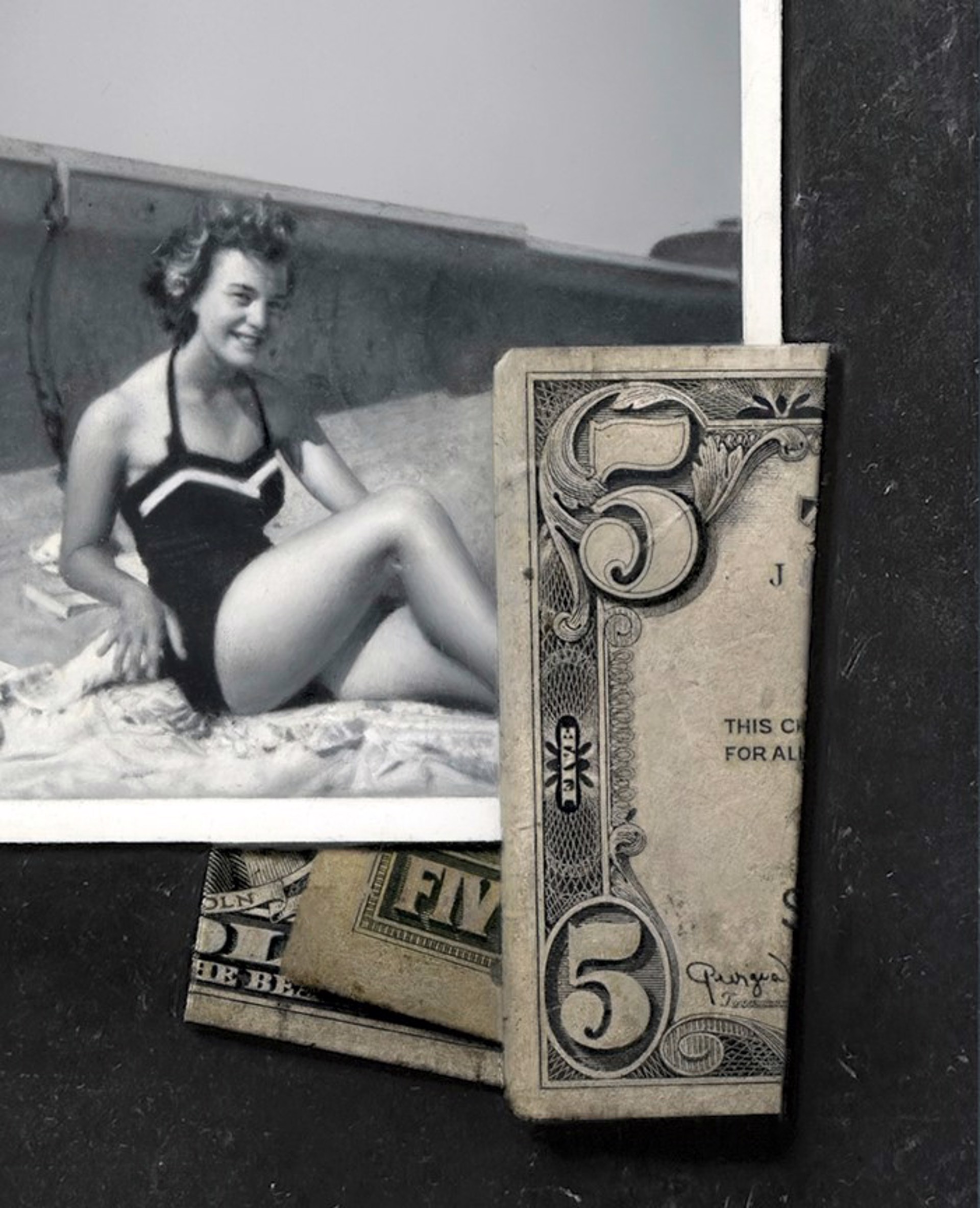 A black-and-white photograph of a figure in a swimsuit sitting on a textured surface, surrounded by vintage playing cards and currency notes.