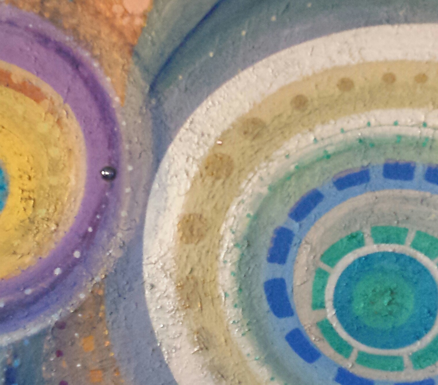 A close up of a colorful painting on a wall.