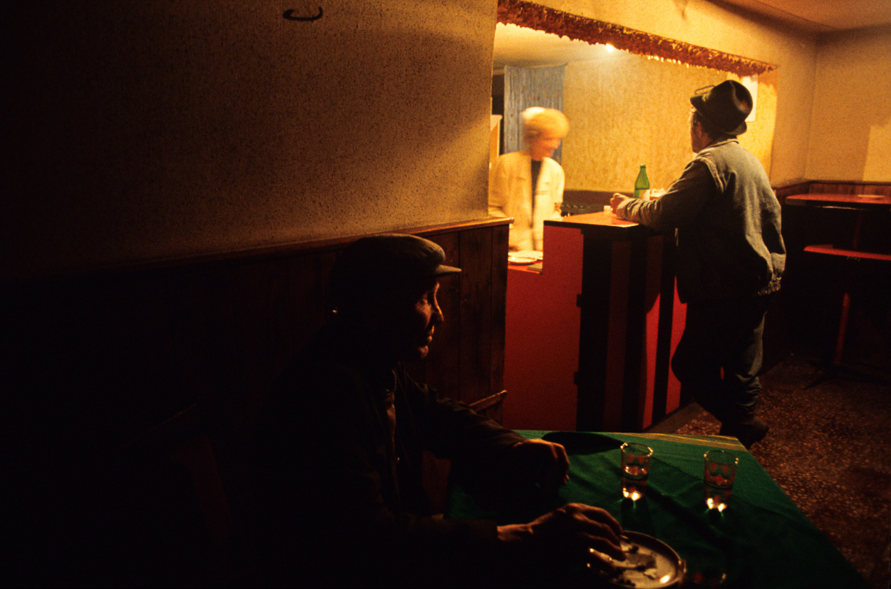A man sitting at a table in a dimly lit room.