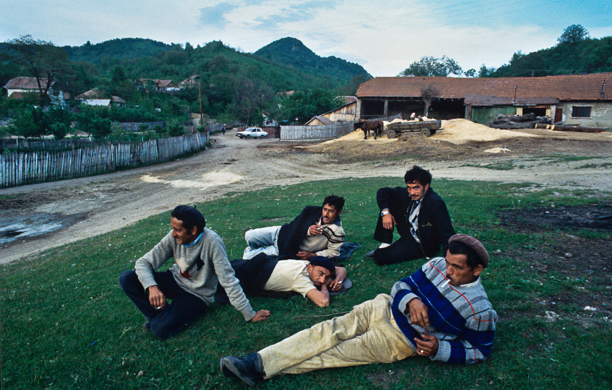 A group of men laying on the grass in a field.