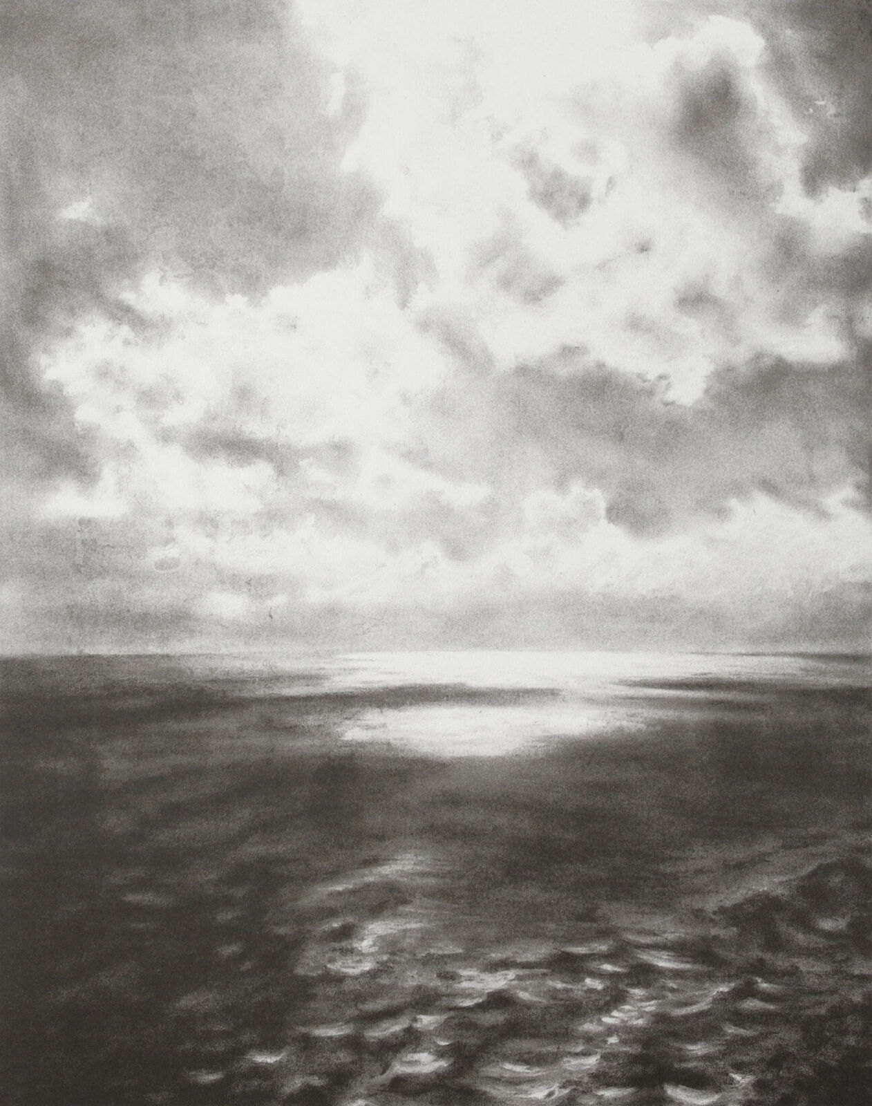 A black and white photo of a cloudy sky over the ocean.