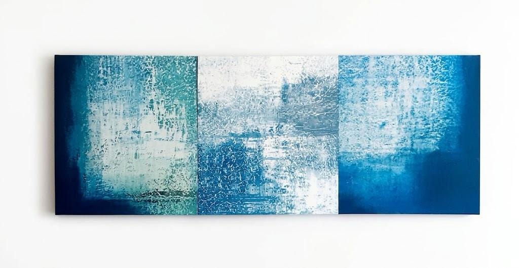 A triptych abstract painting featuring textured blue and white brushstrokes on a white background.