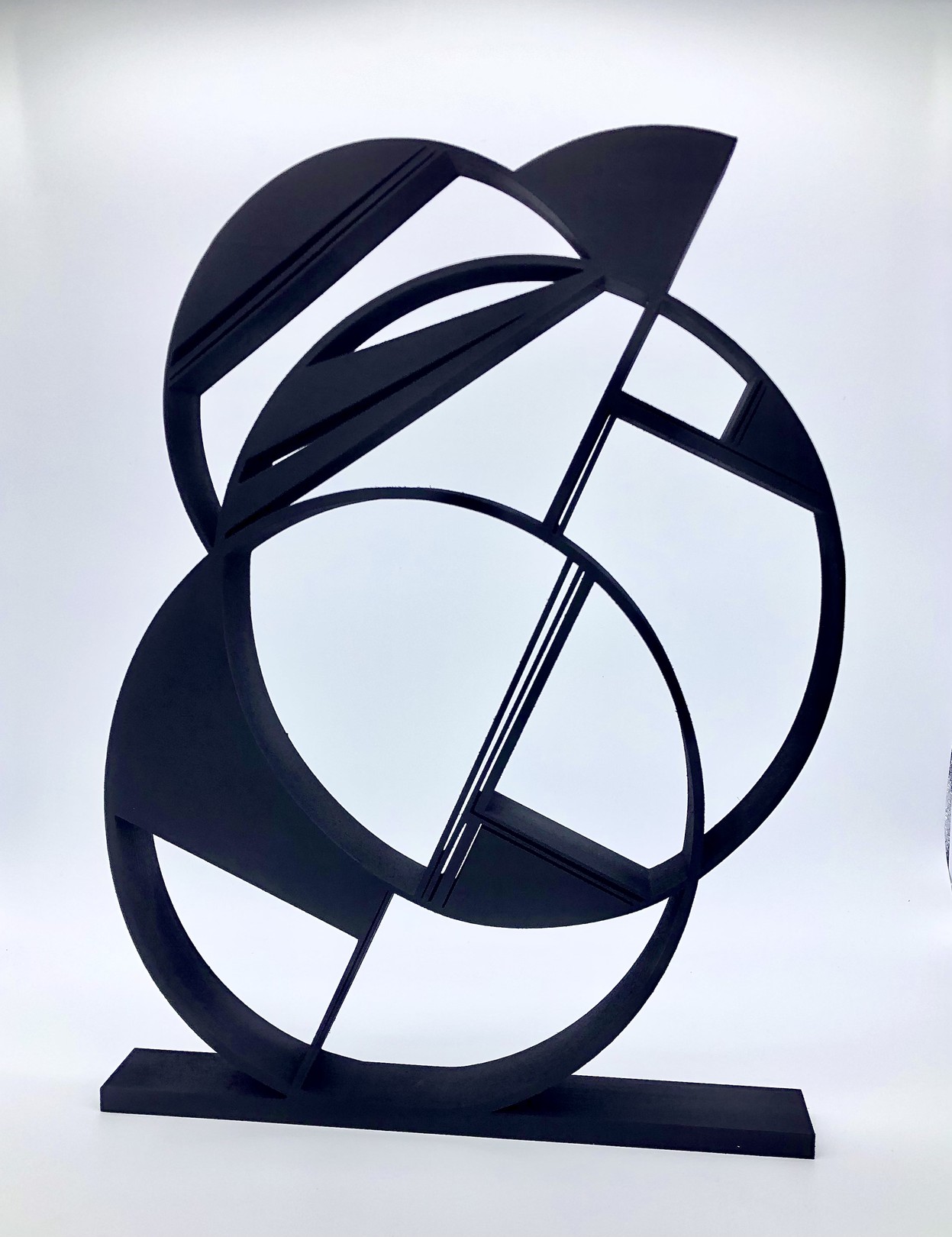 A black metal sculpture on a white surface.