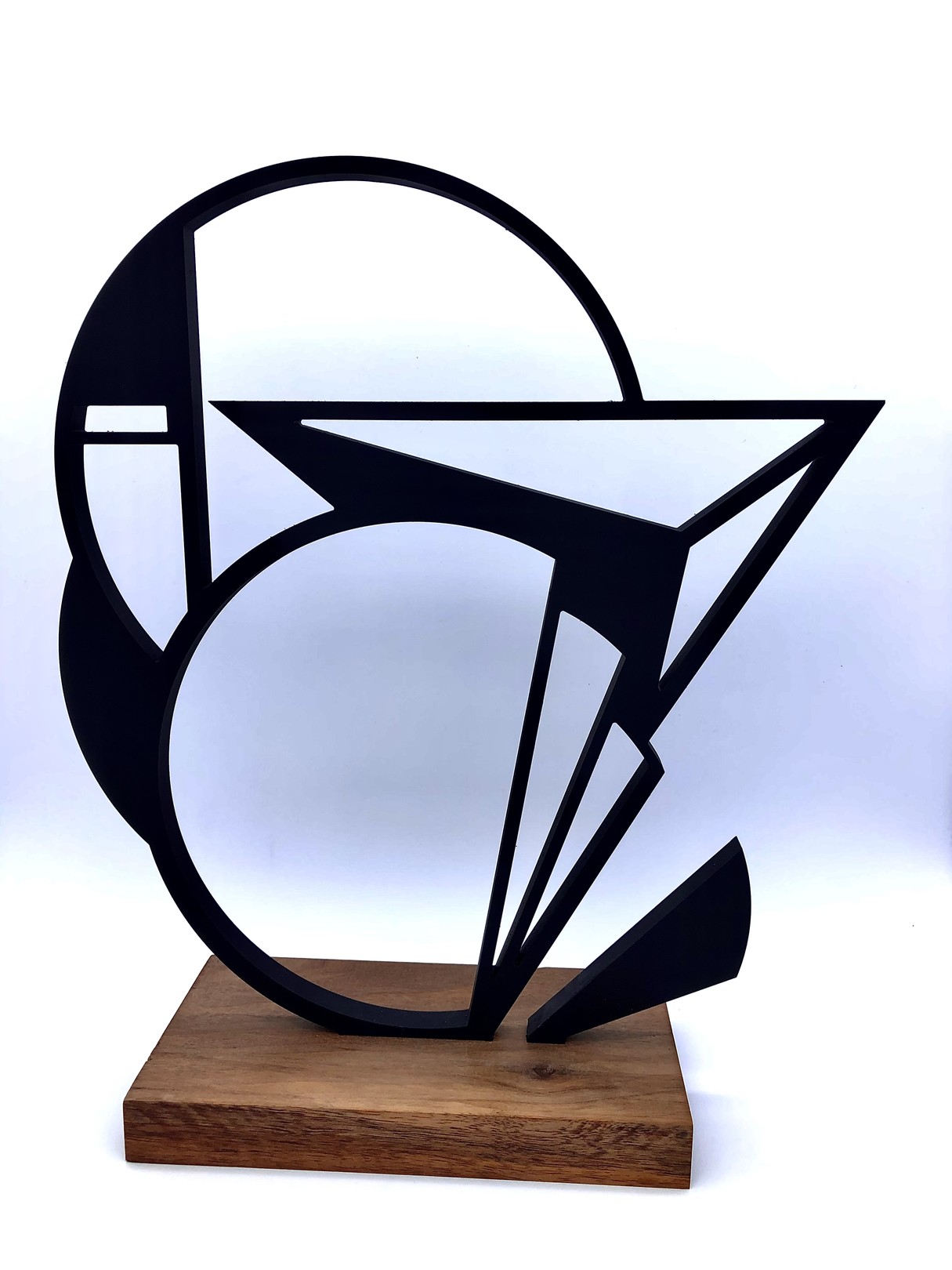 A black and white sculpture on a wooden base.