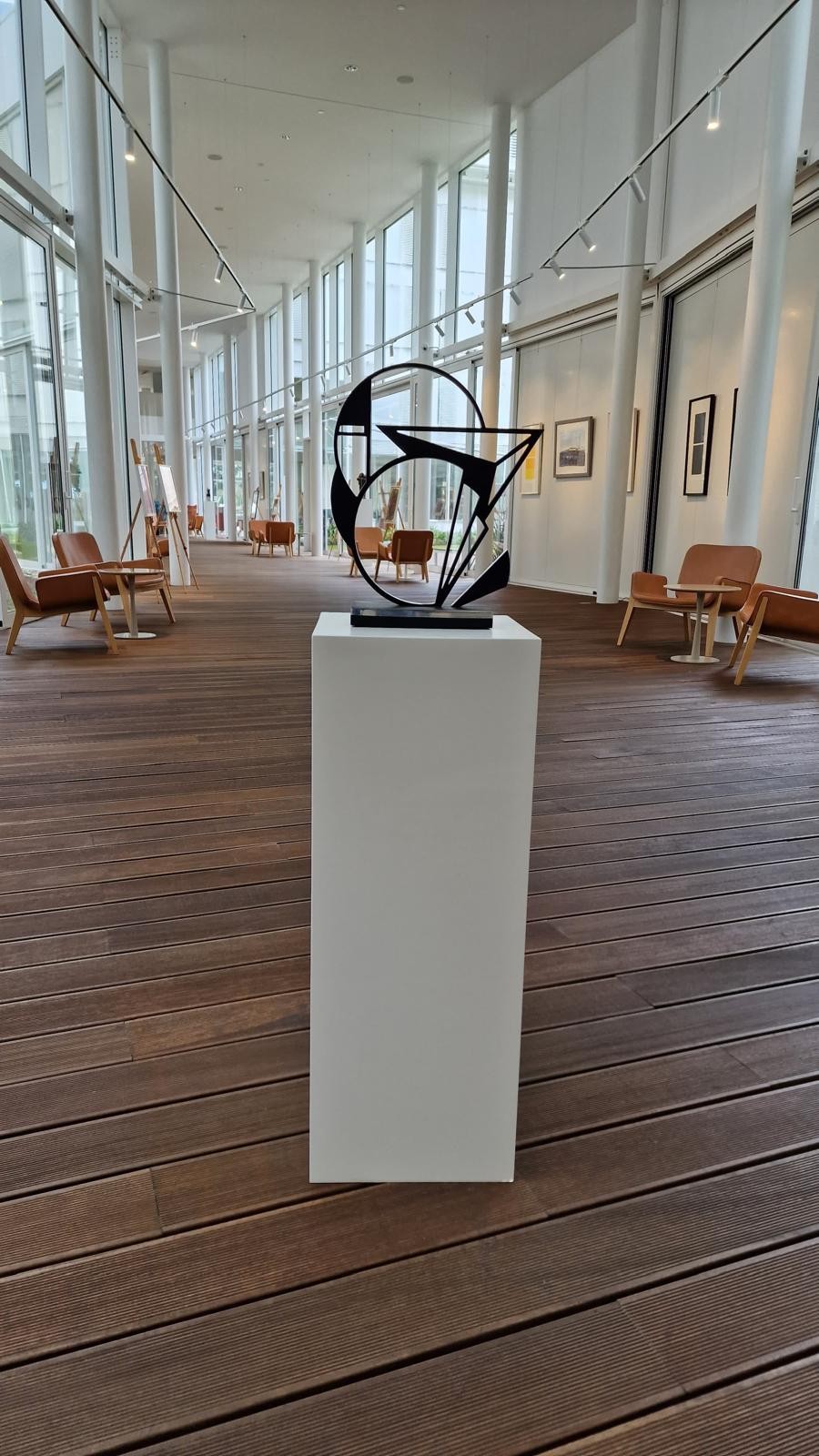 A black and white sculpture on a wooden base.