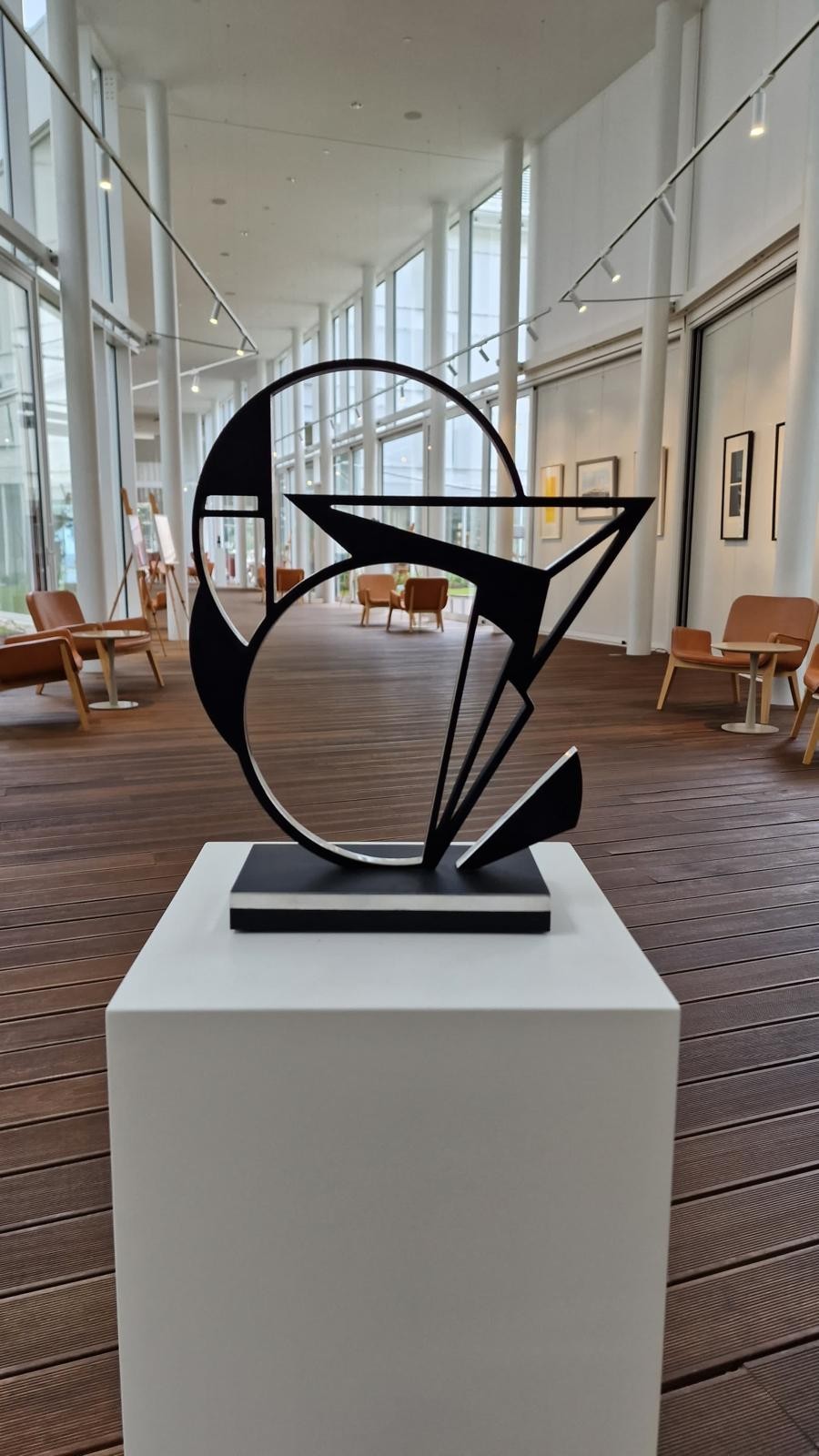 A black and white sculpture on a wooden base.